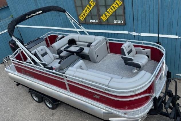 2026 Sun Tracker SportFish 20 DLX pontoon boat with red and silver design, parked on trailer.