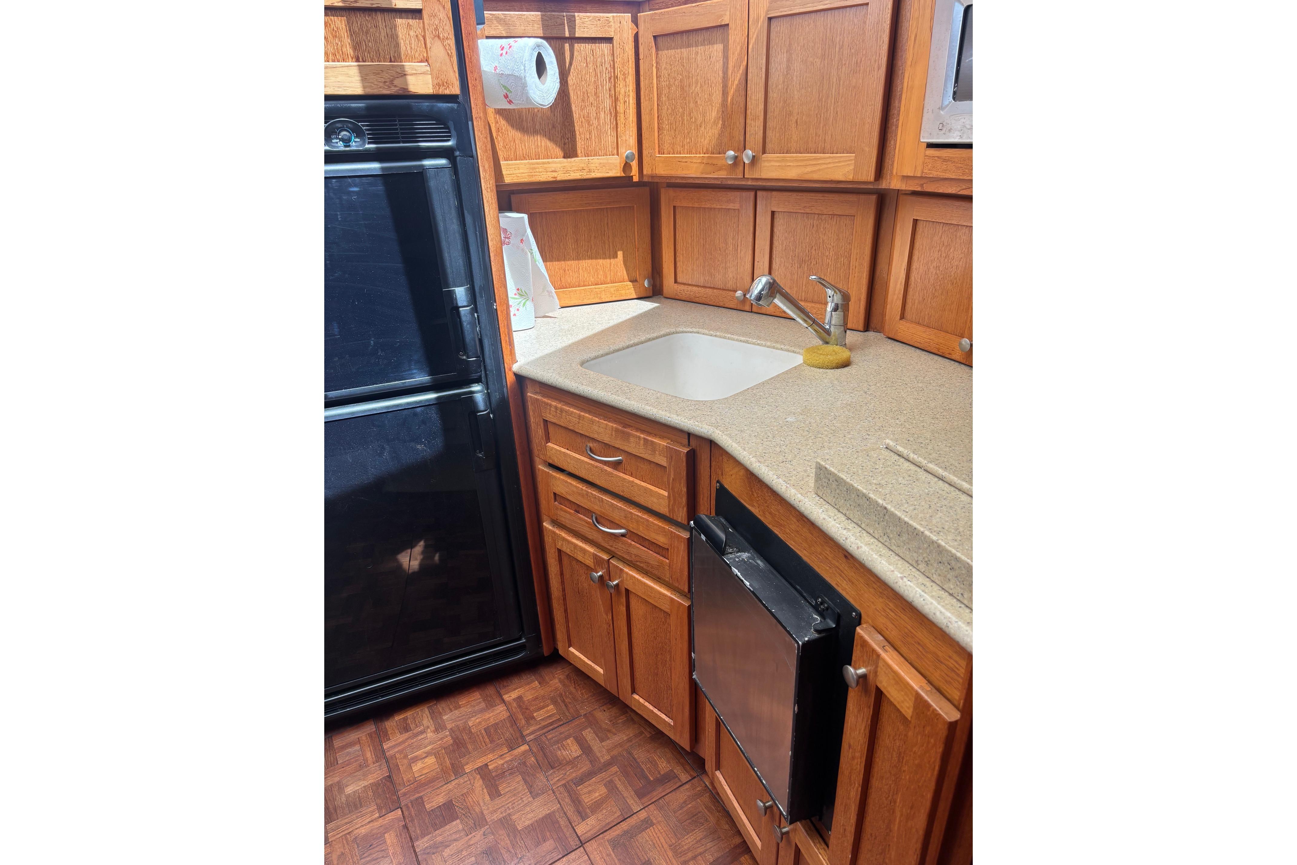 1995 Carver 356 Aft Cabin Motor Yacht kitchen with wooden cabinets and modern appliances.