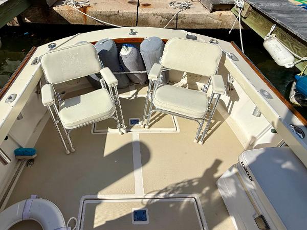 1978 Dyer 29 Trunk Cabin boat interior with two white chairs and docked setting.