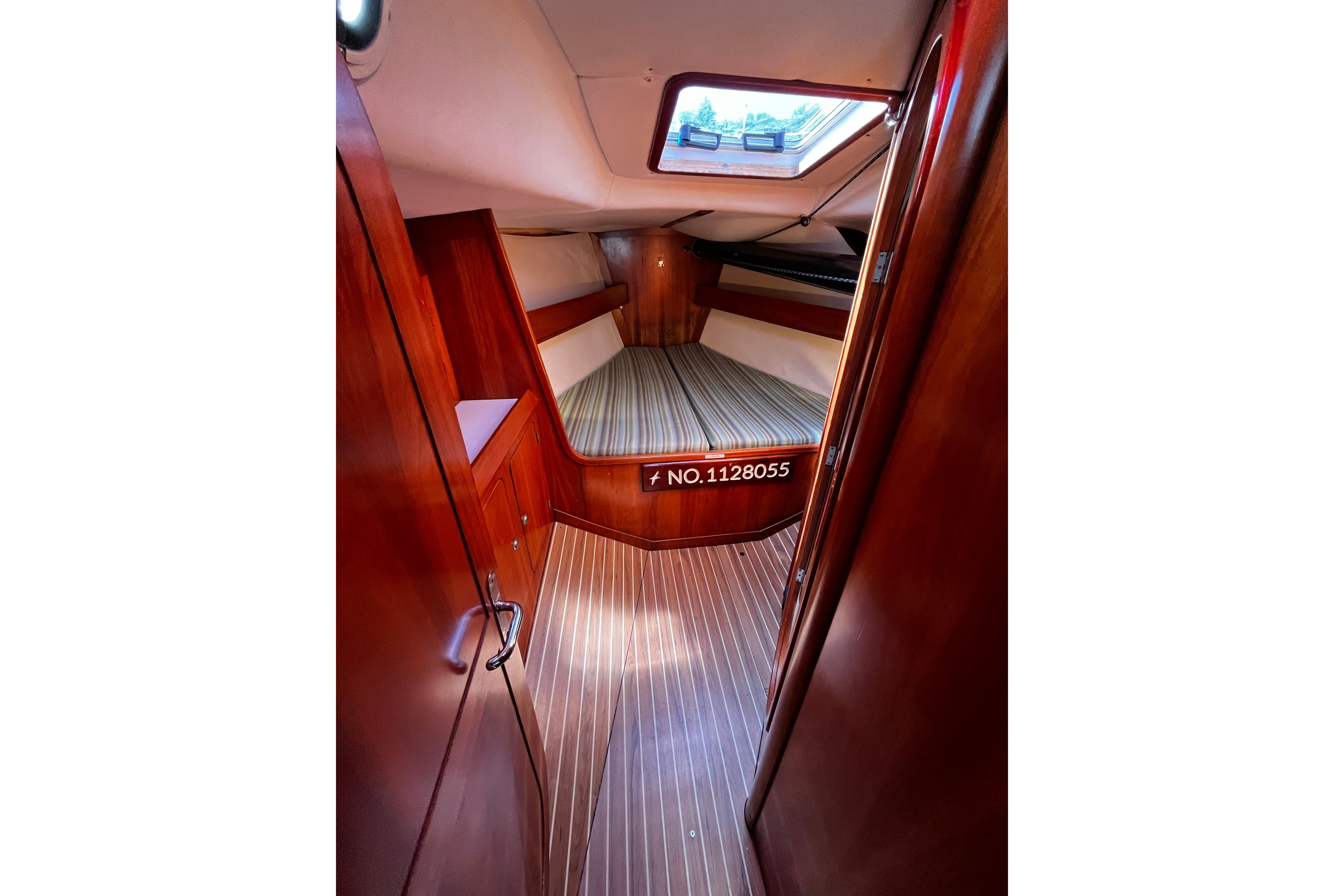 1998 J Boats J/120 cabin interior with wood finish and striped flooring.