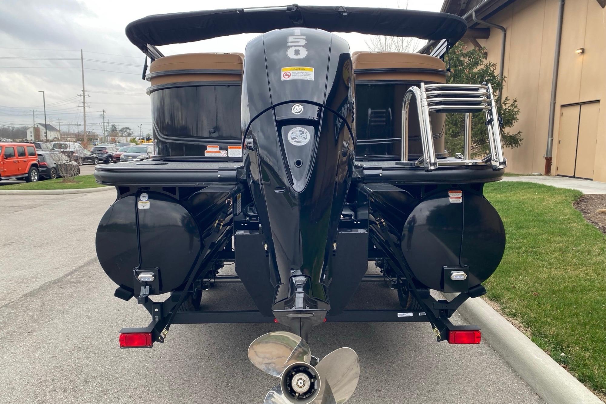 2026 Regency 230 DL pontoon boat with powerful outboard motor, parked outdoors.