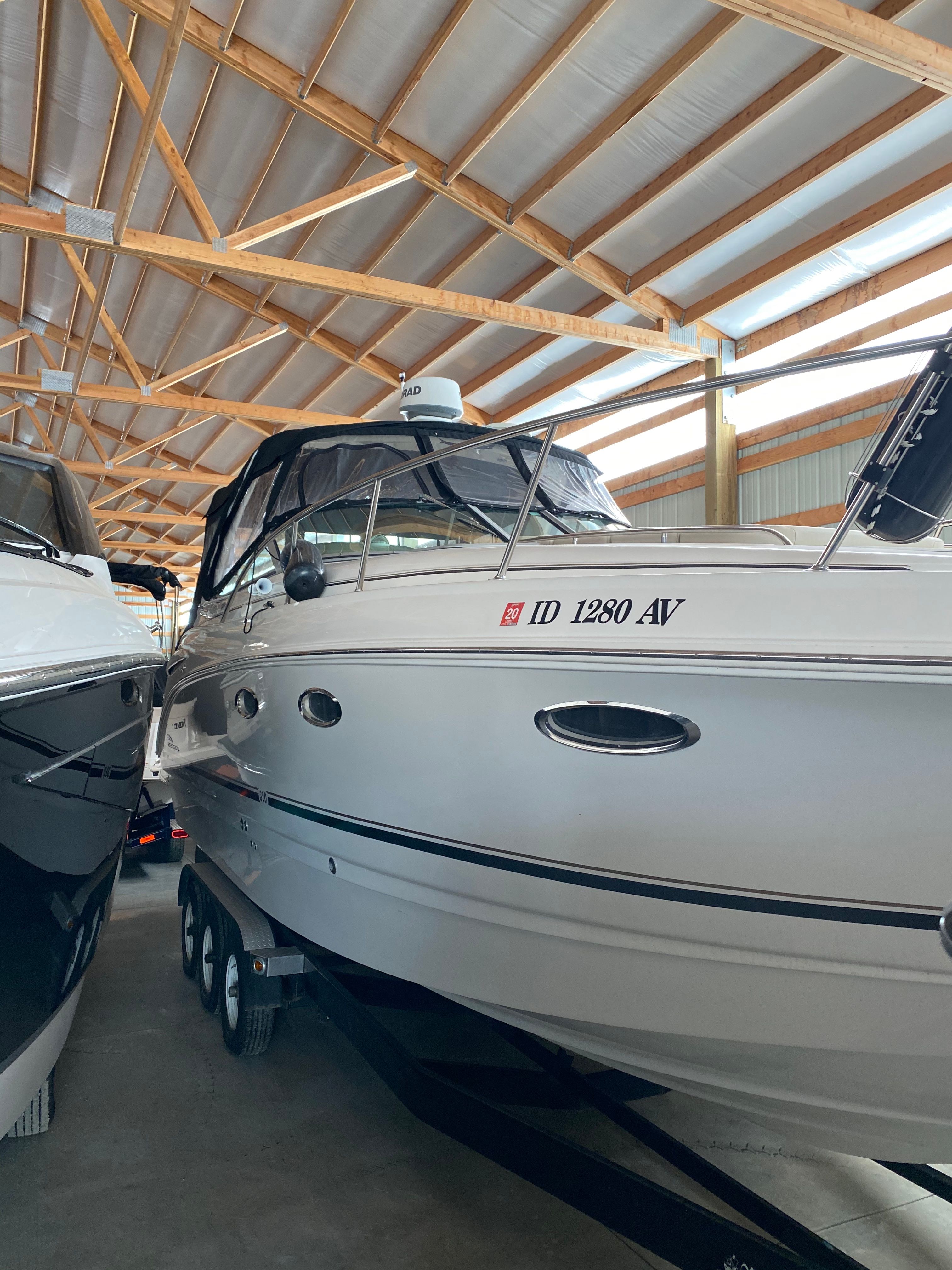 A 2004 Chaparral Signature 330 is stored in a covered warehouse. It features a sleek design.