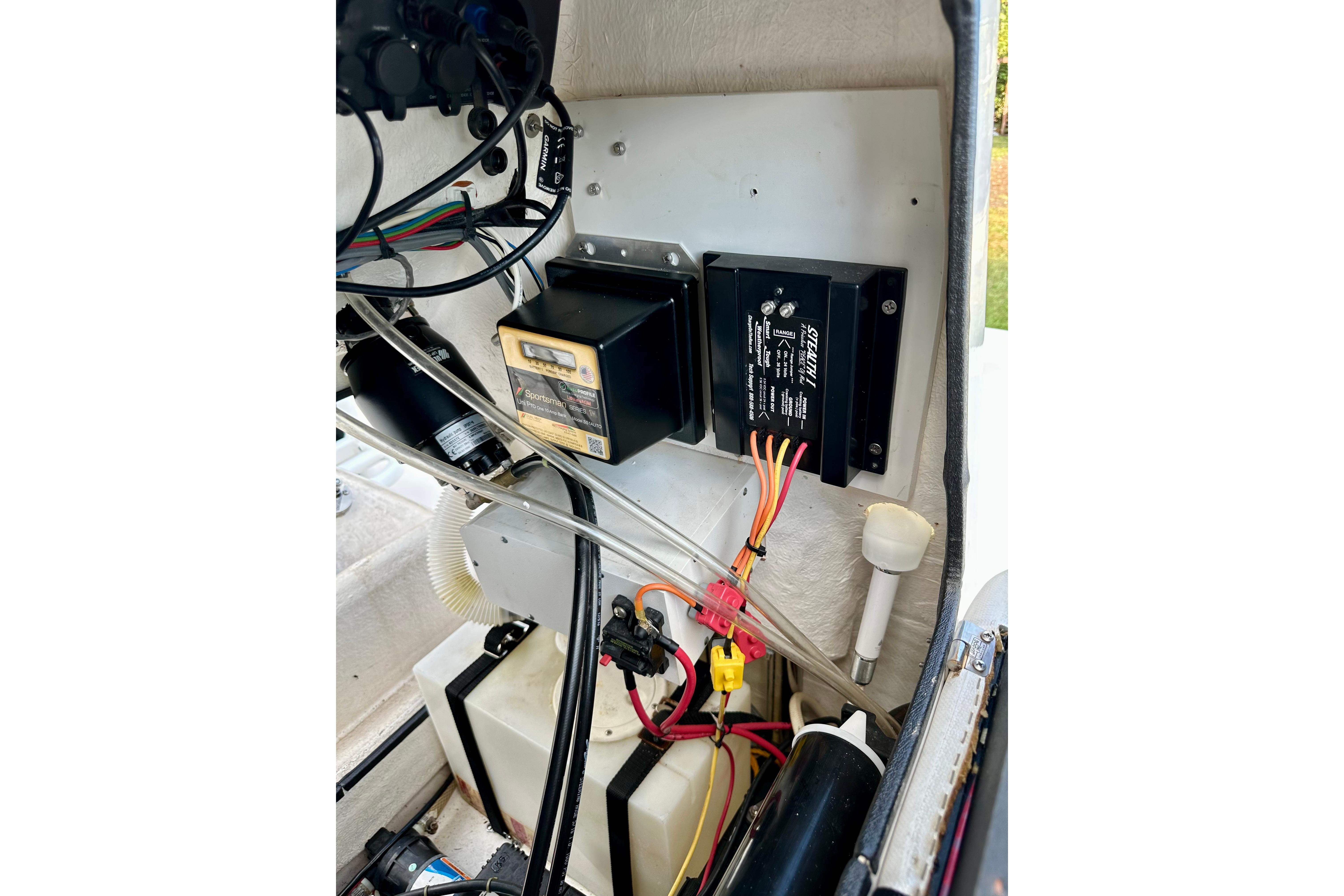 Electrical components inside a 2017 Blue Wave 2400 PureBay boat, featuring wiring and control boxes.