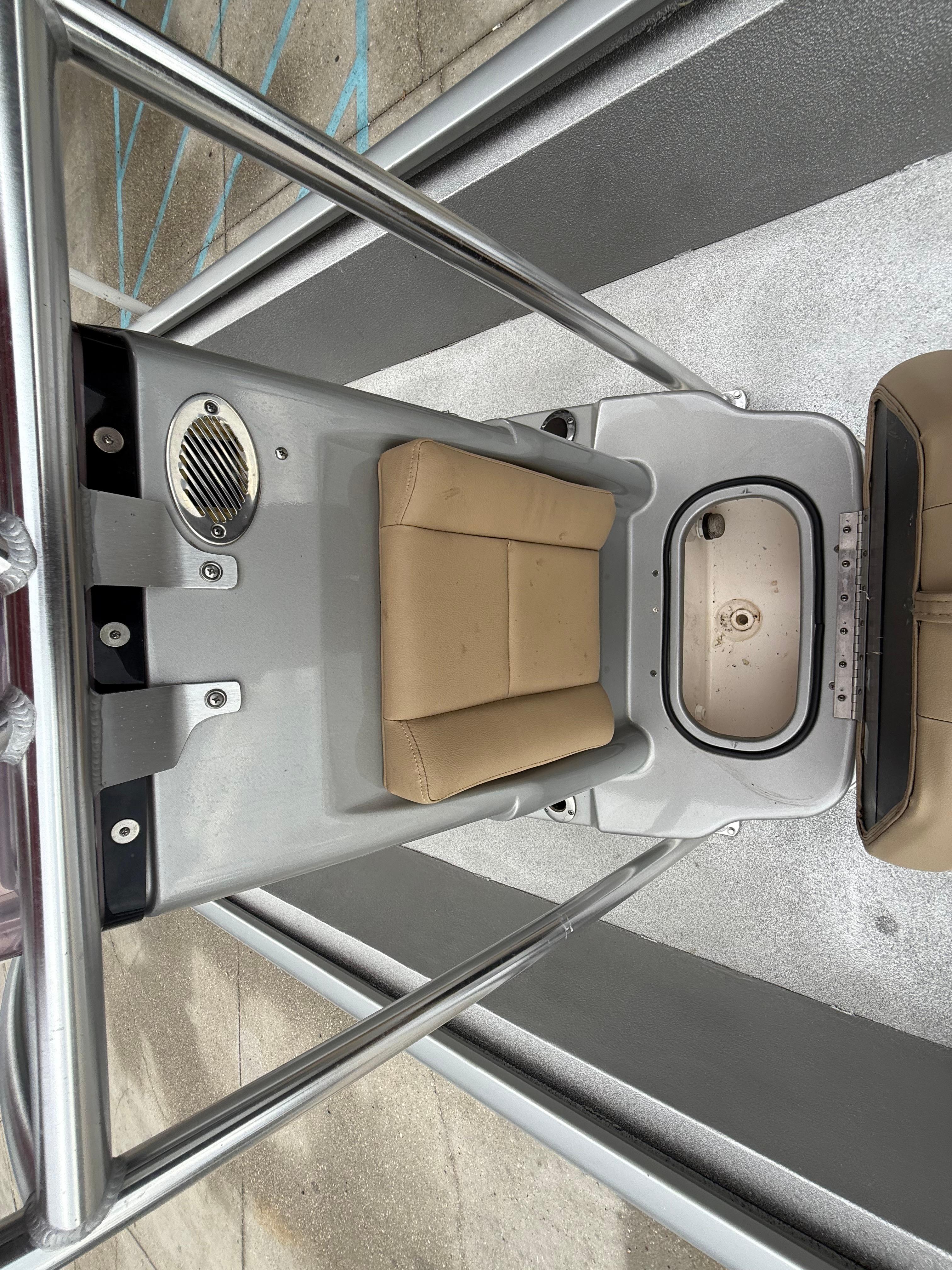 Interior of a 2020 Avid 23 FS Platinum boat with tan seating and storage compartment.