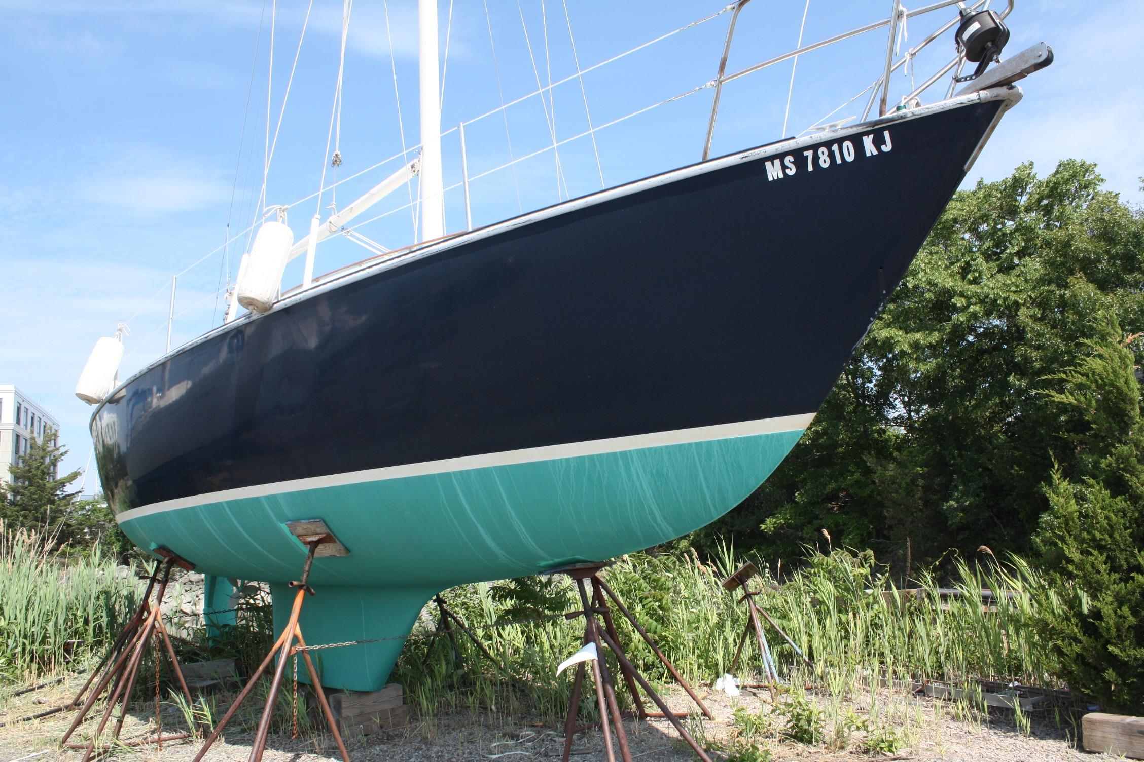 1981 S2 9.2A sailboat on stands, dark blue hull, green bottom, outdoors.