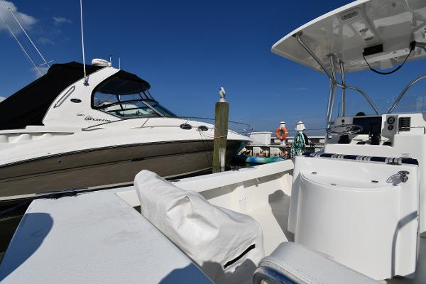 2021 Eastern 248 Center Console boat docked near another vessel on a sunny day.