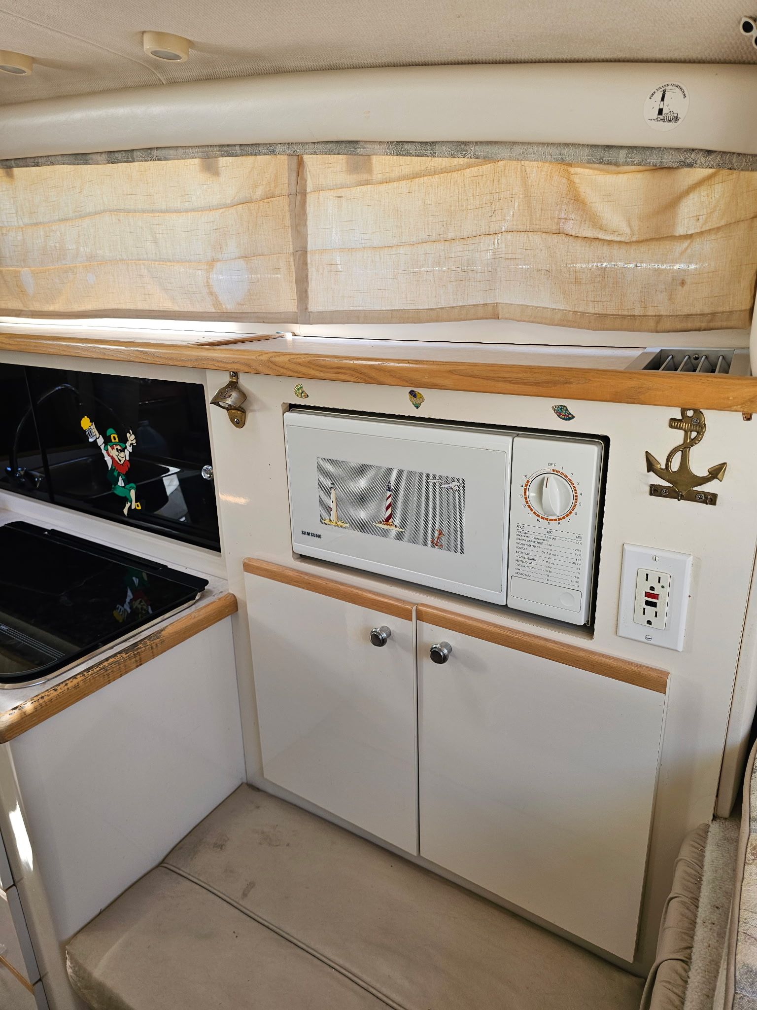 Interior of a 1998 Bayliner 2855 Ciera Sunbridge with microwave and curtains.