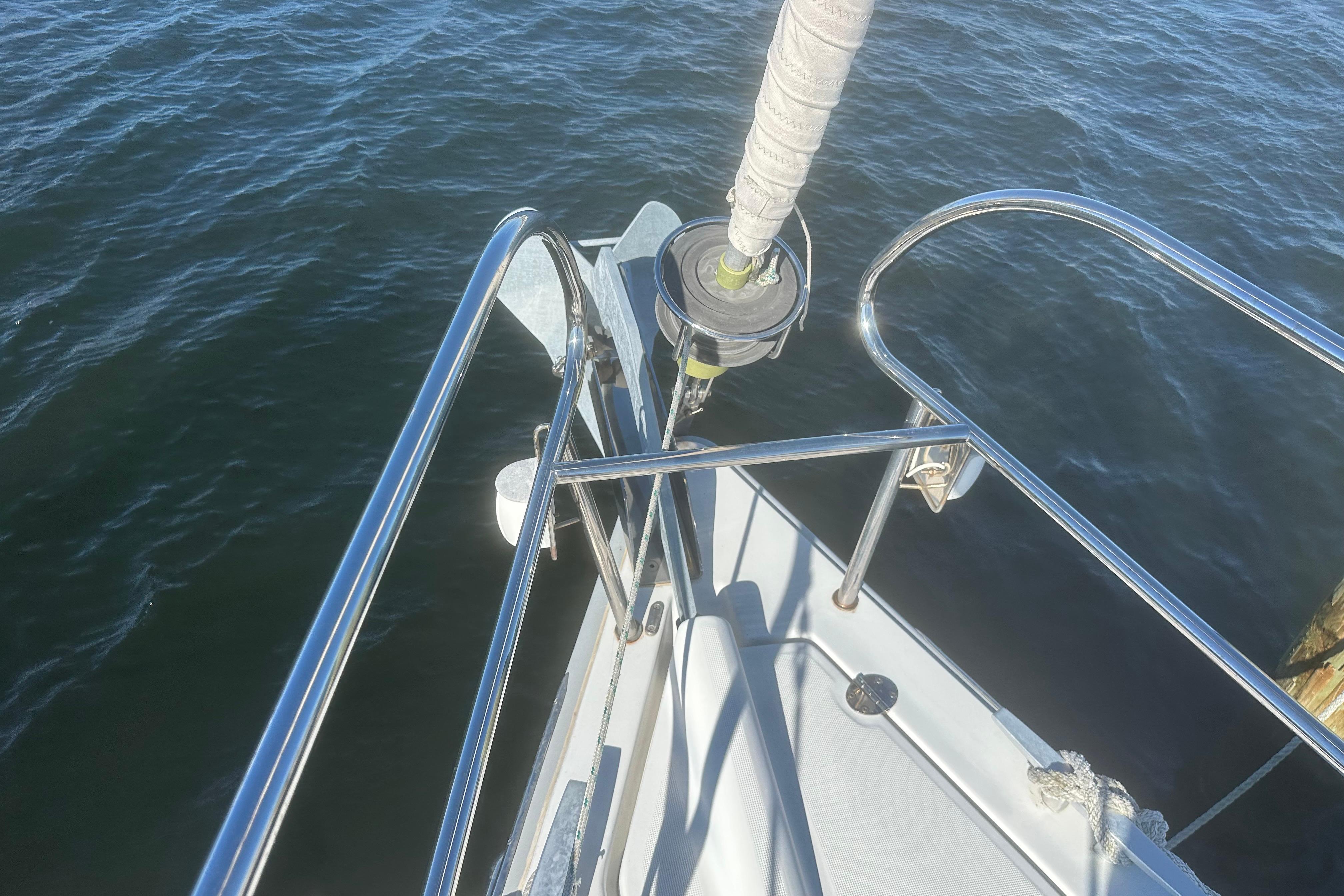 Beneteau Oceanis 37 sailboat bow, 2015 model, with stainless steel railings over water.