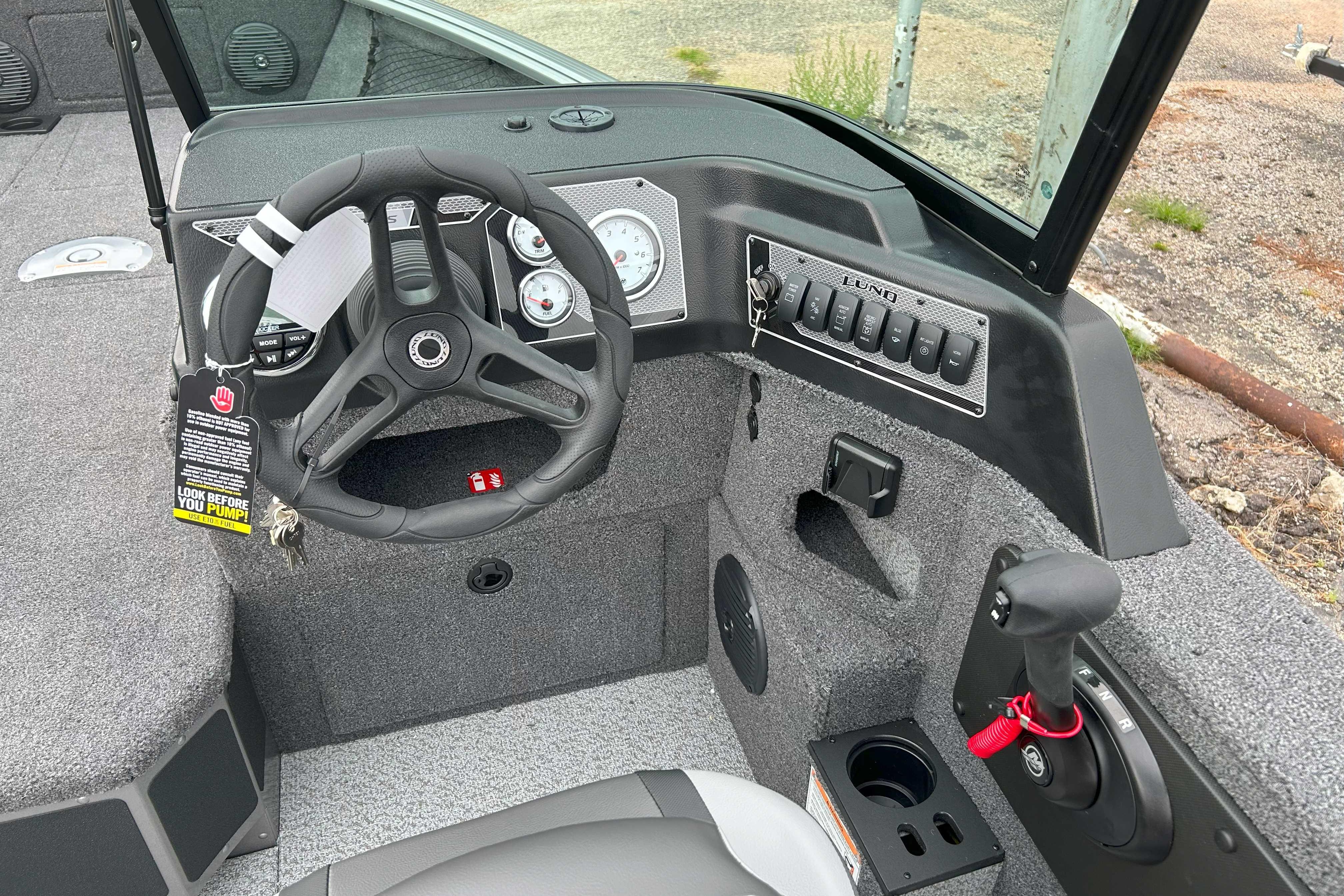 2026 Lund 1875 Impact XS Sport boat dashboard with steering wheel and control panel.
