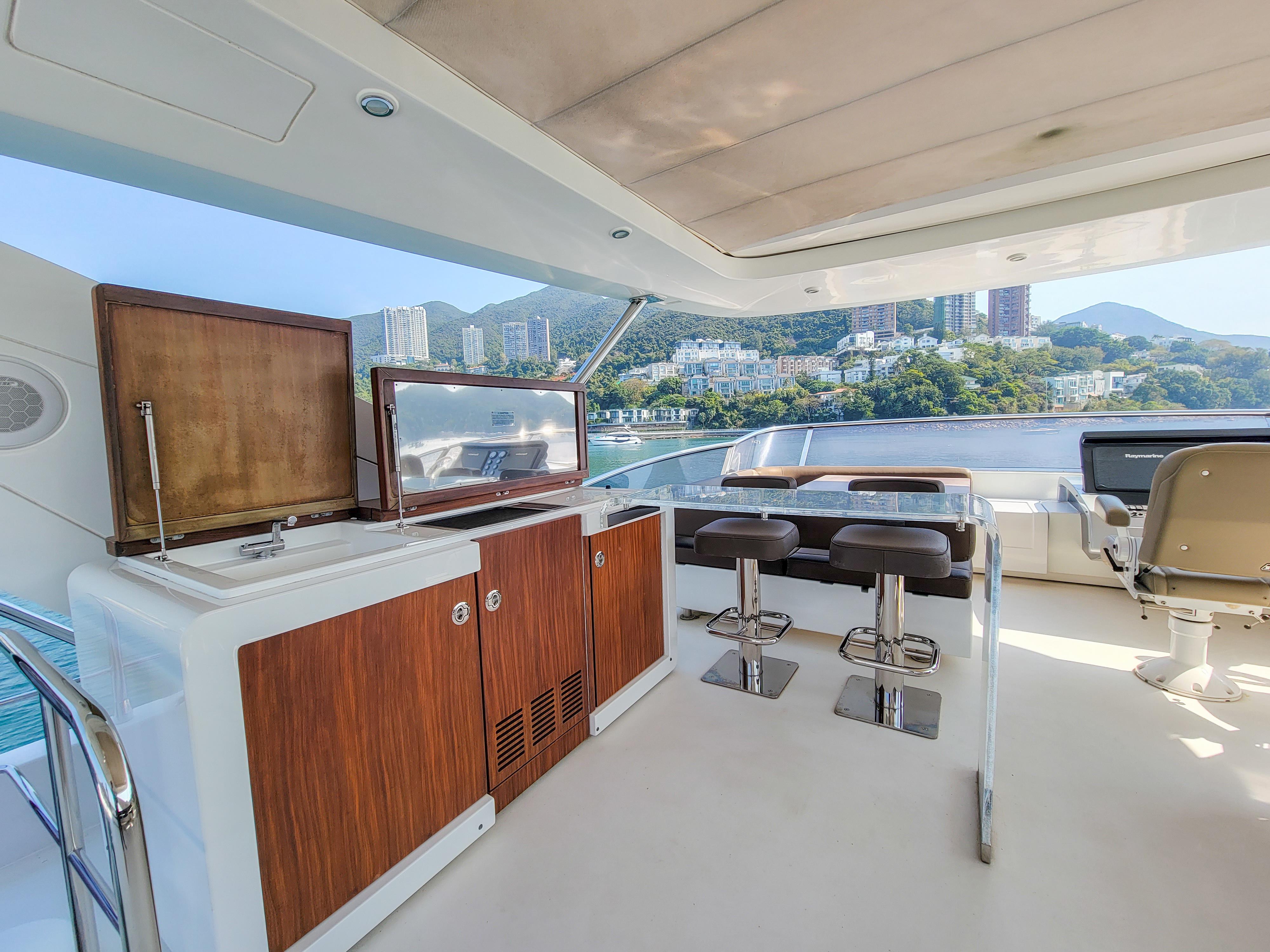 Luxurious 2015 Azimut 80 yacht deck with bar, stools, and scenic waterfront view.