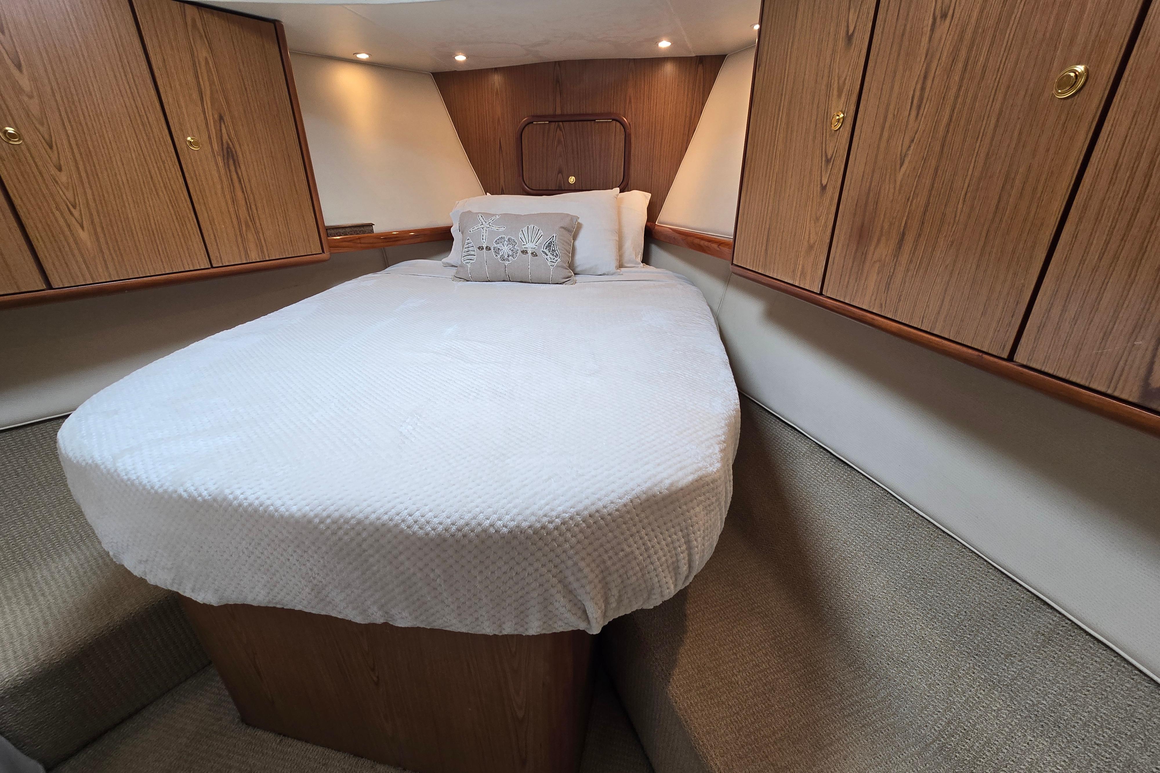 Luxurious cabin interior of 2007 Ocean Yachts 46 Super Sport with cozy bed and wooden cabinets.