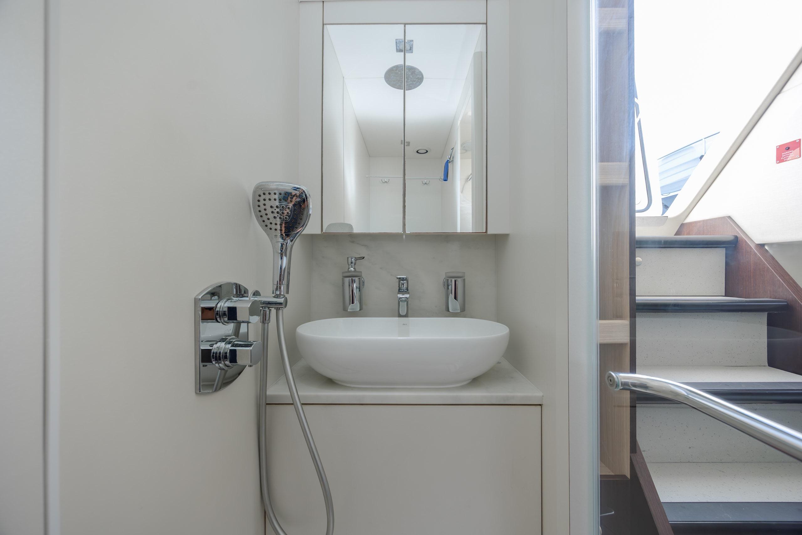 Modern bathroom on 2020 Sunseeker Predator 74 XPS yacht, featuring sleek fixtures and mirror.