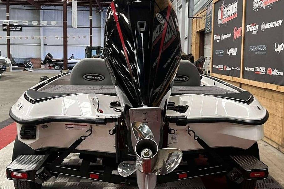 2026 Triton 18 TrX boat in showroom, rear view with powerful outboard motor.