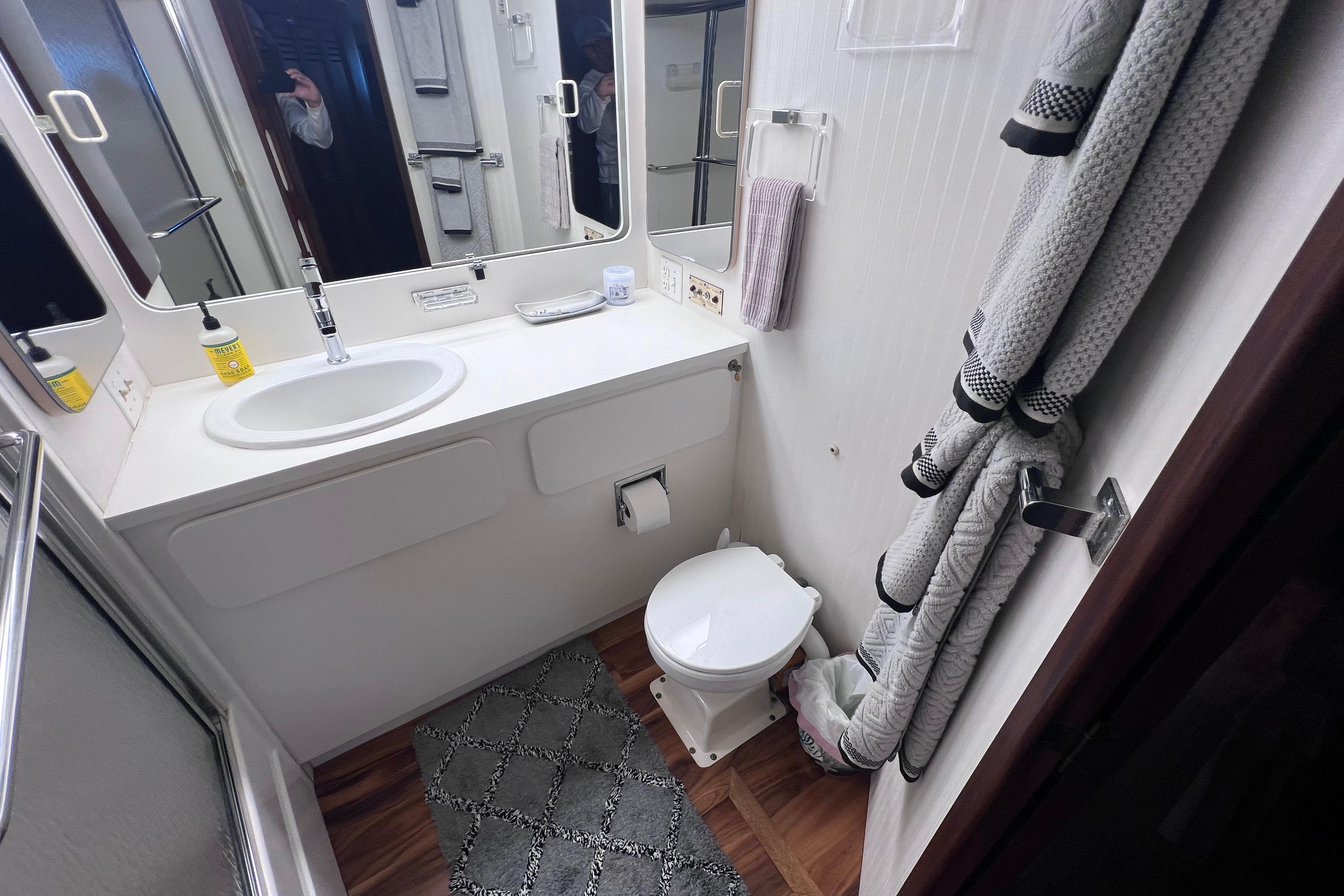 Bathroom interior of 1987 Hatteras 70 Cockpit Motor Yacht, featuring sink and toilet.