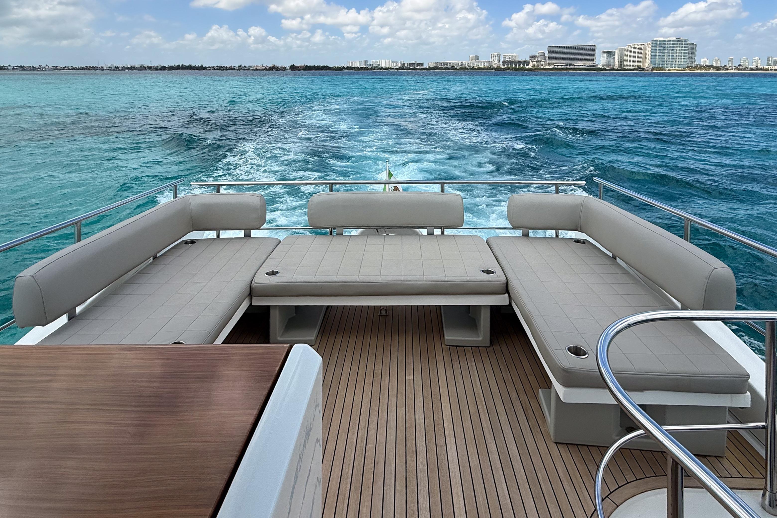 Luxurious 2016 Azimut 50 yacht deck with seating, cruising on turquoise waters.