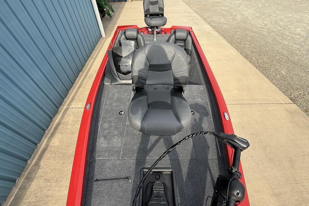 2026 Tracker Pro Team 175 boat with gray seating and red trim, parked on concrete.