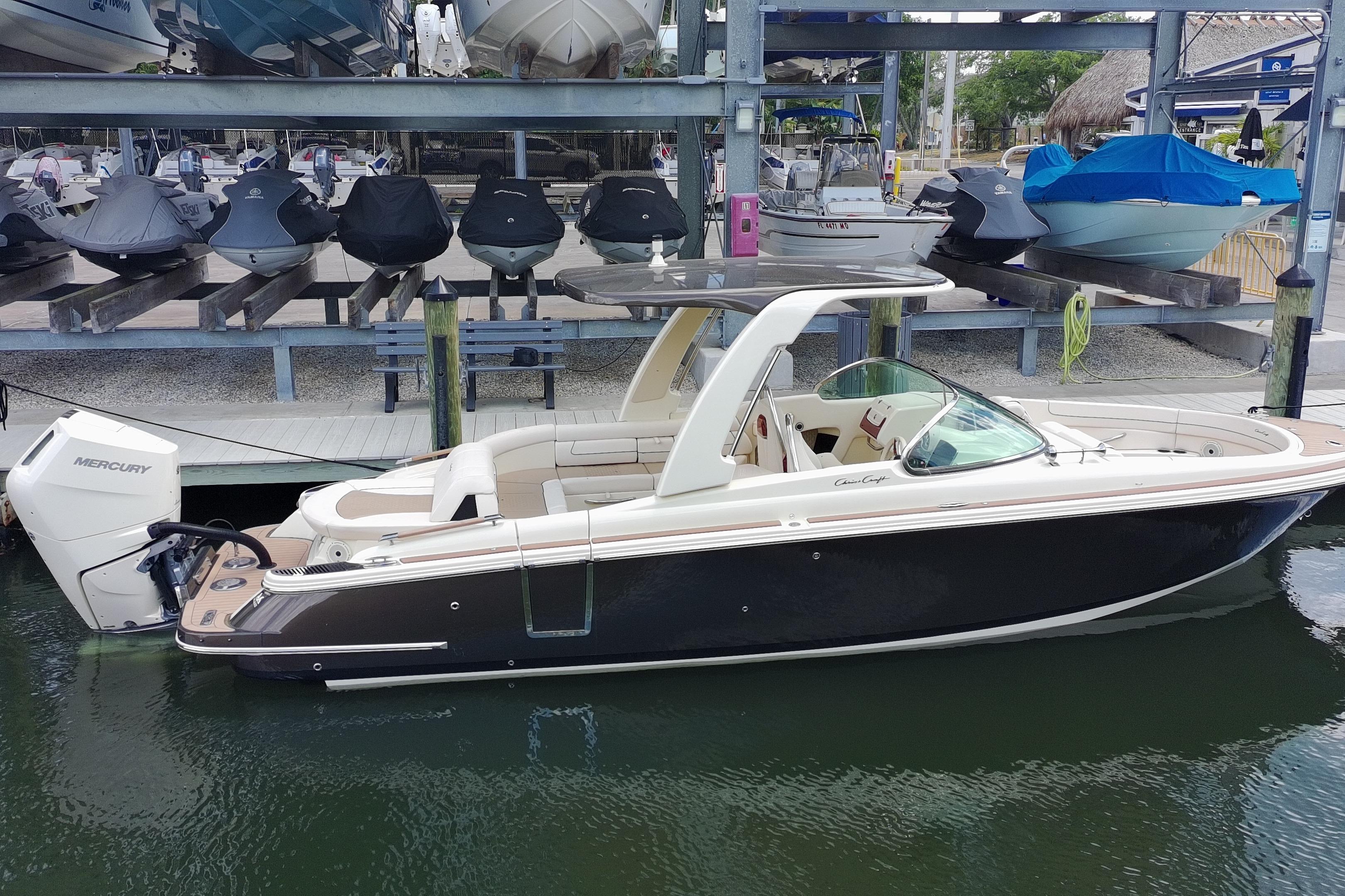 2024 Chris-Craft Launch 28 GT boat docked, featuring sleek design and Mercury outboard engine.