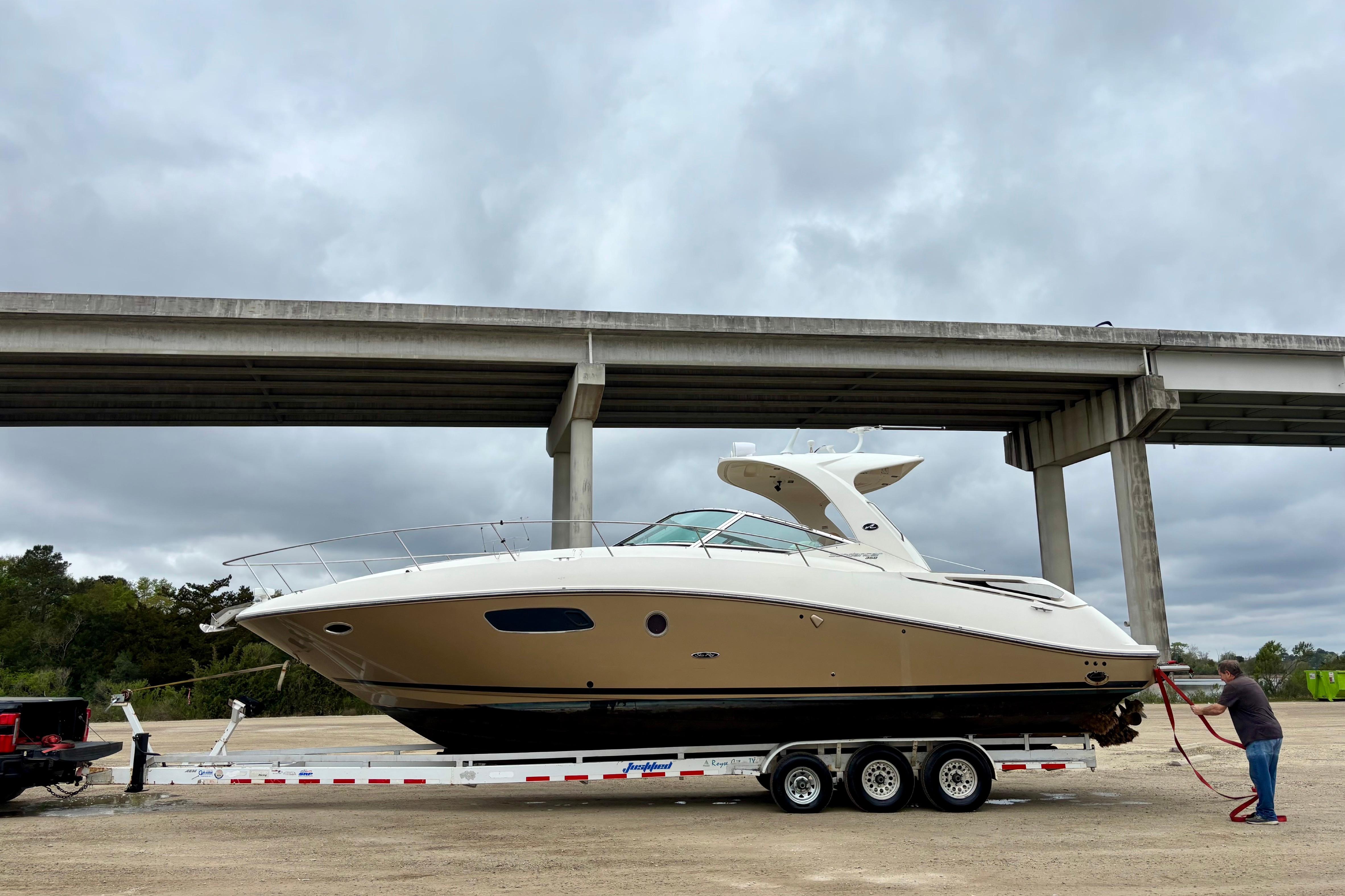 2009 Sea Ray Sundancer 350 yacht on trailer under cloudy sky.