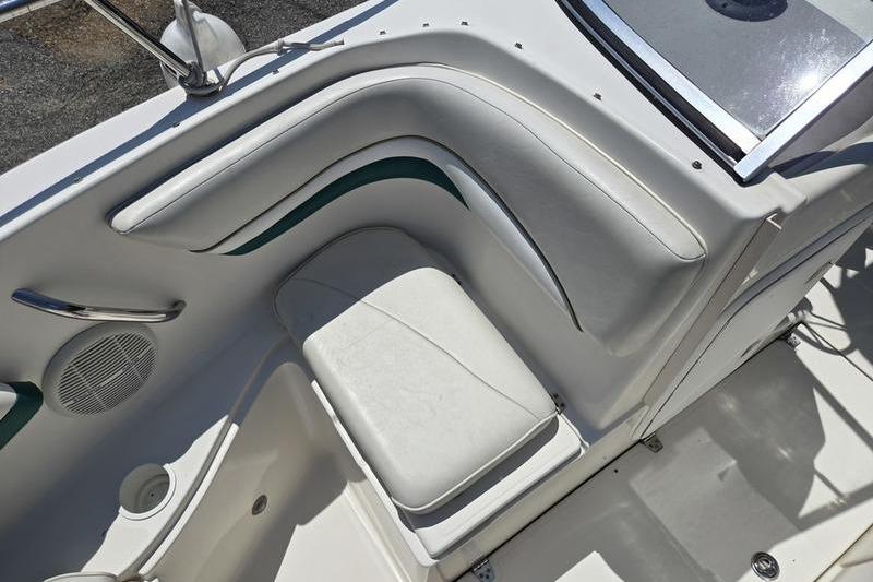 2004 Aquasport 215 Osprey Sport boat interior with white seating and speaker.