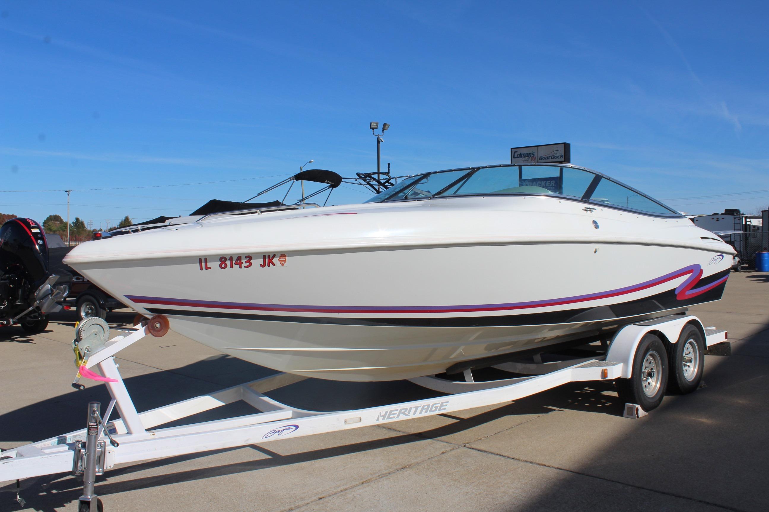 1996 Baja 232 speedboat on trailer, white with red accents, parked outdoors.