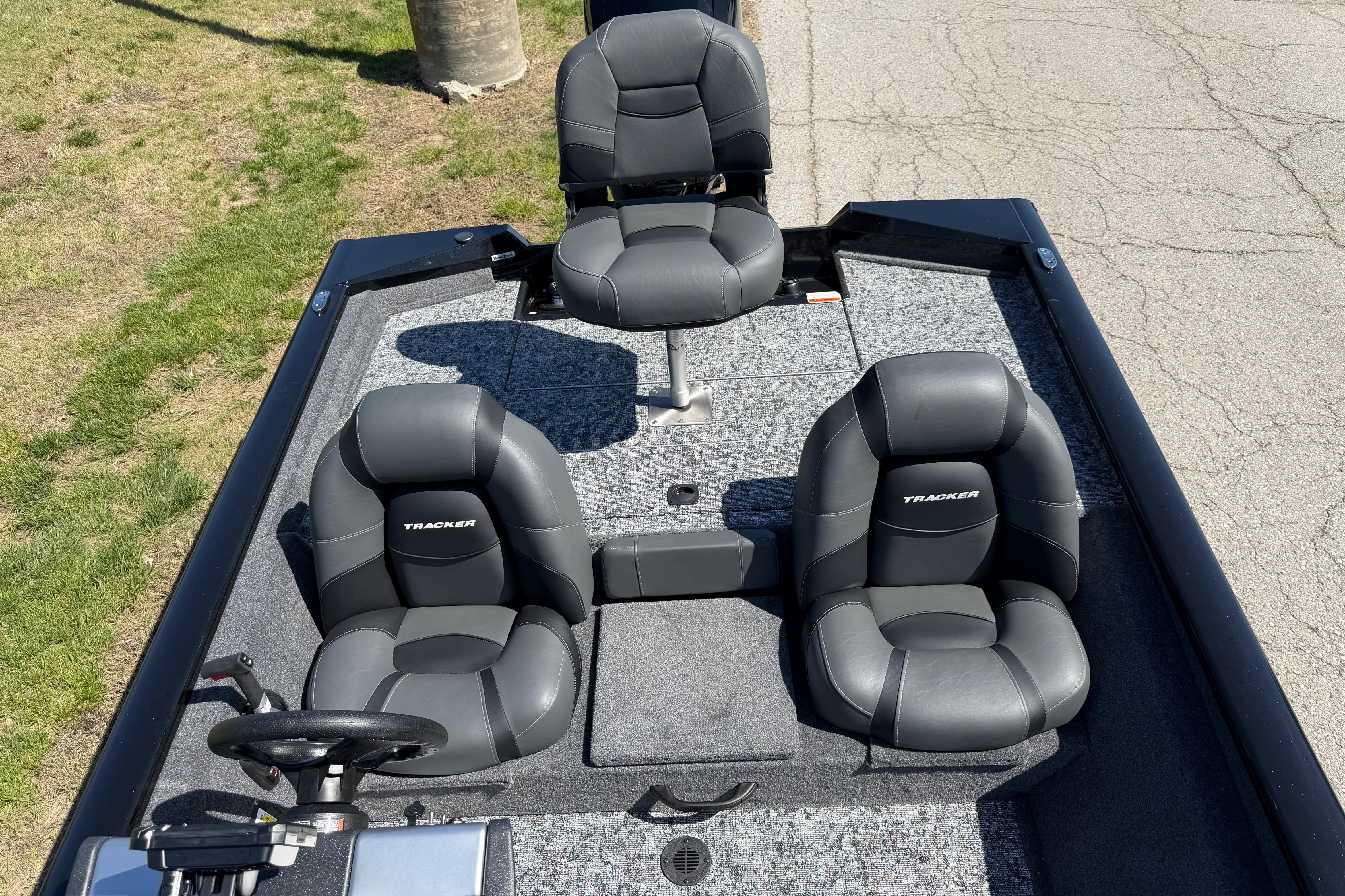 2026 Tracker Pro Team 175 boat interior with three black seats on a sunny day.