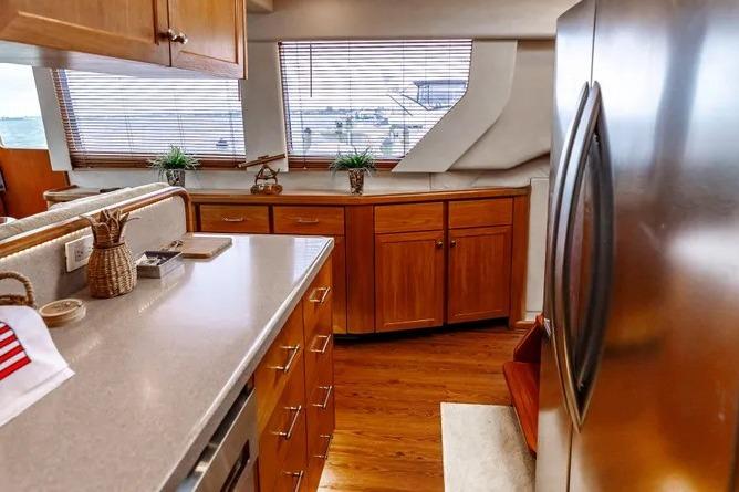Luxurious kitchen interior of 2000 Pacific Mariner 65 Motoryacht with wooden cabinets and modern appliances.