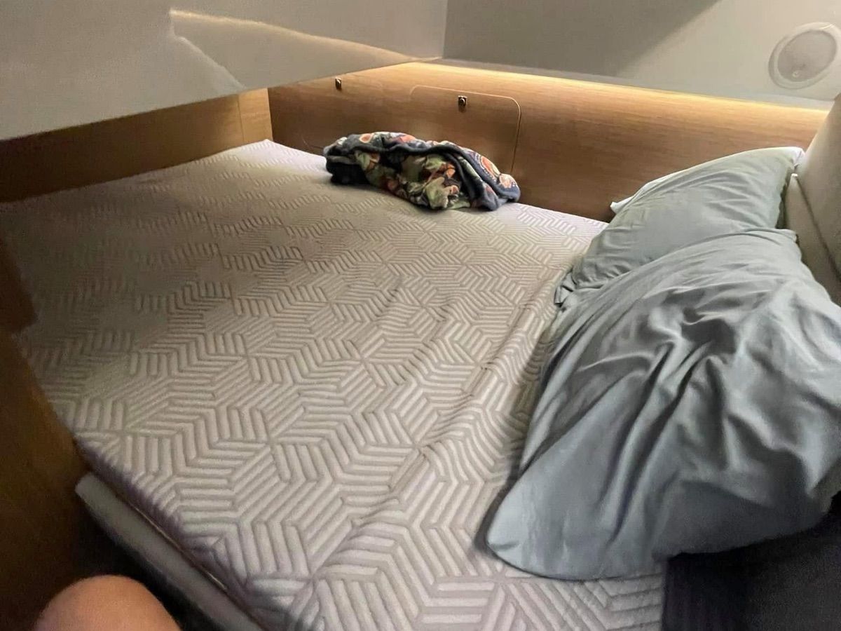 Cabin with a cozy bed and pillows on a Jeanneau NC 895.