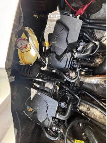 Two engines inside a boat, connected with hoses and cables.