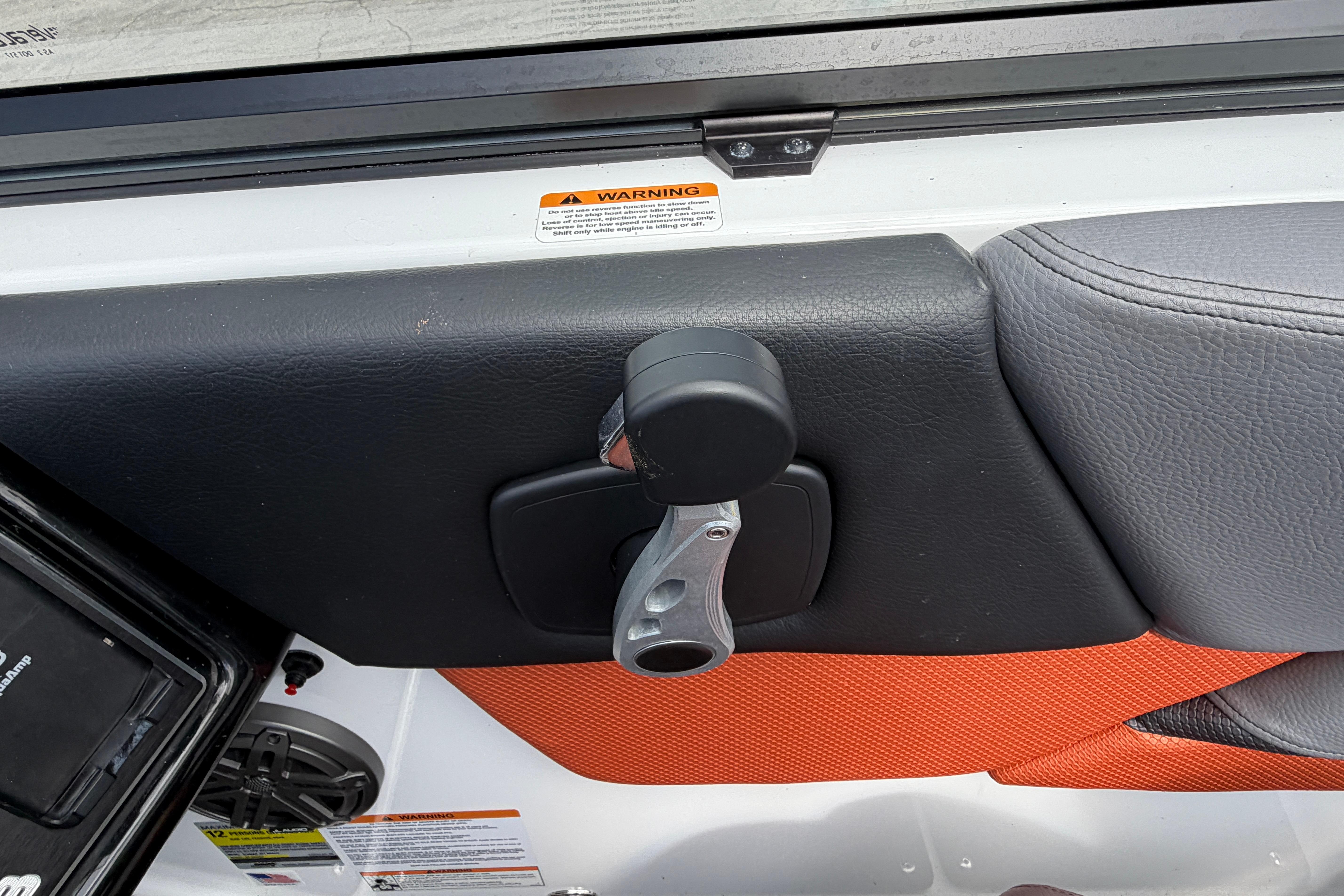 Interior detail of 2026 Scarab 235 LX boat, featuring a sleek handle and warning labels.