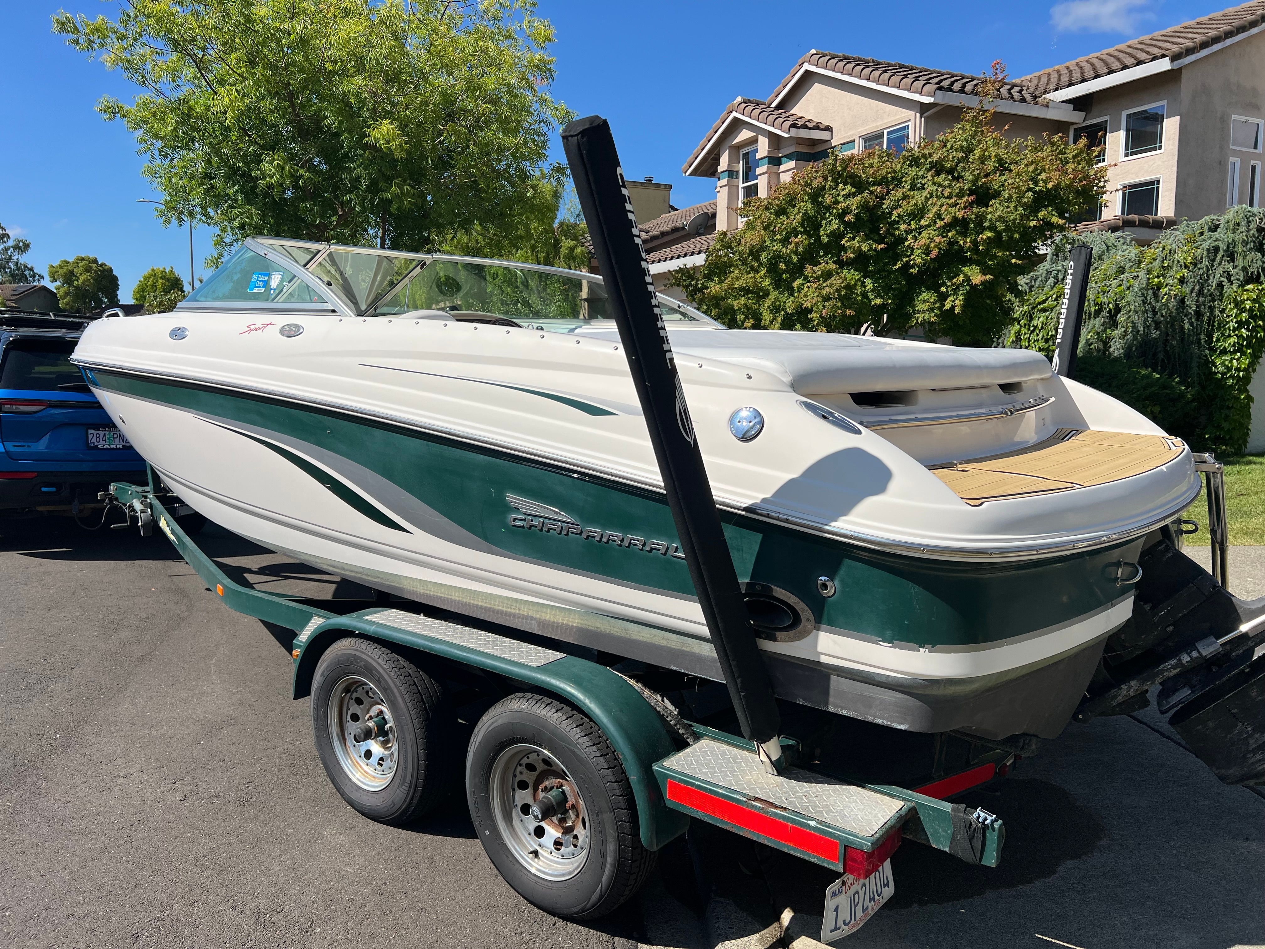 2001 Chaparral 216 SSi boat on trailer, green and white, in residential area.