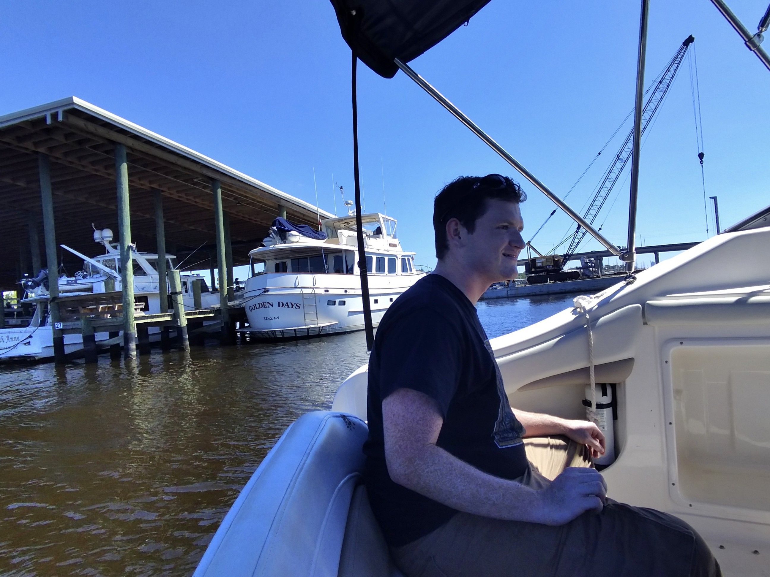 Person on Regal Commodore 2465 boat, harbor in background.