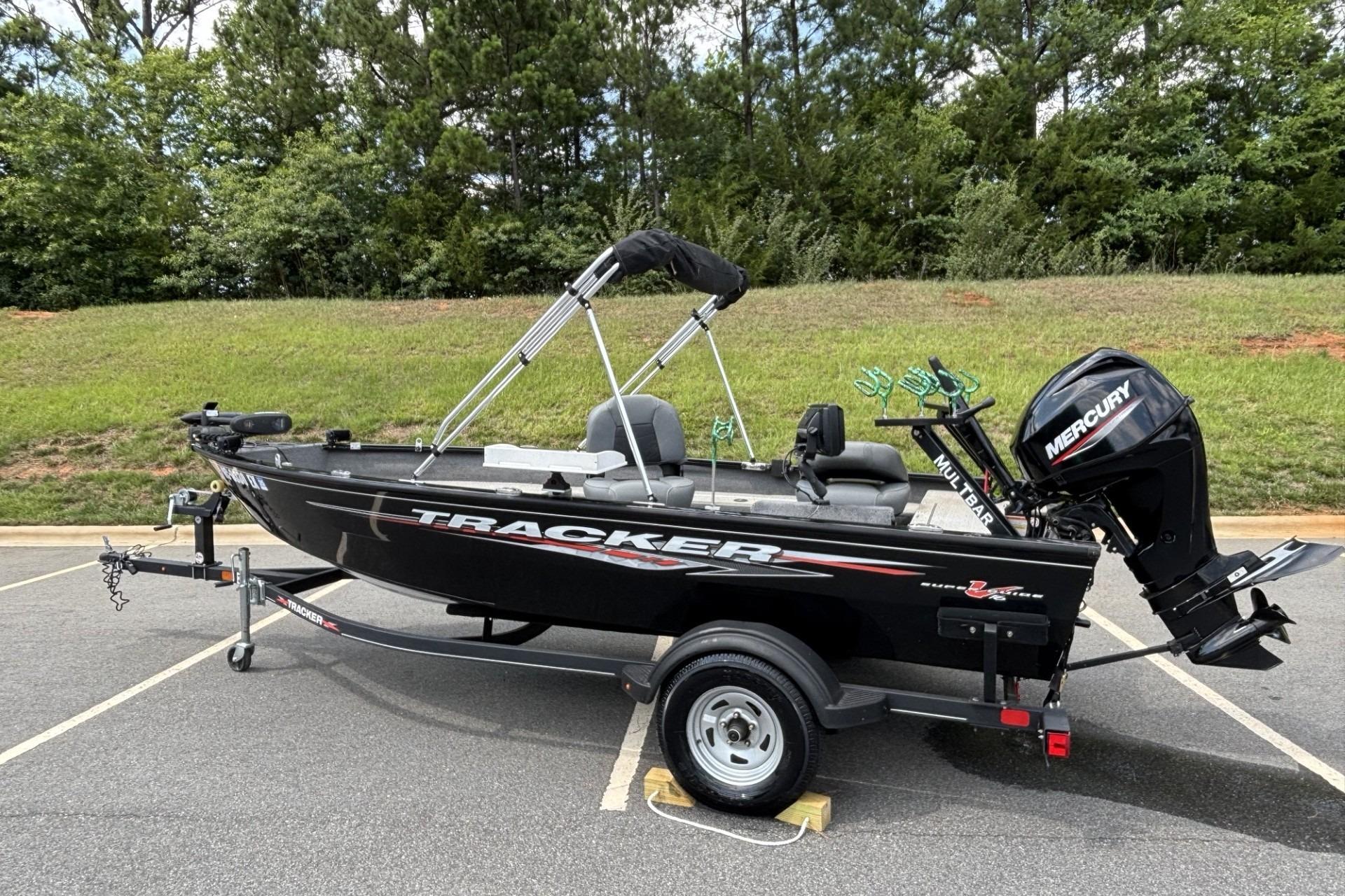 2022 Tracker Super Guide V-16 T fishing boat with Mercury motor in a parking lot.
