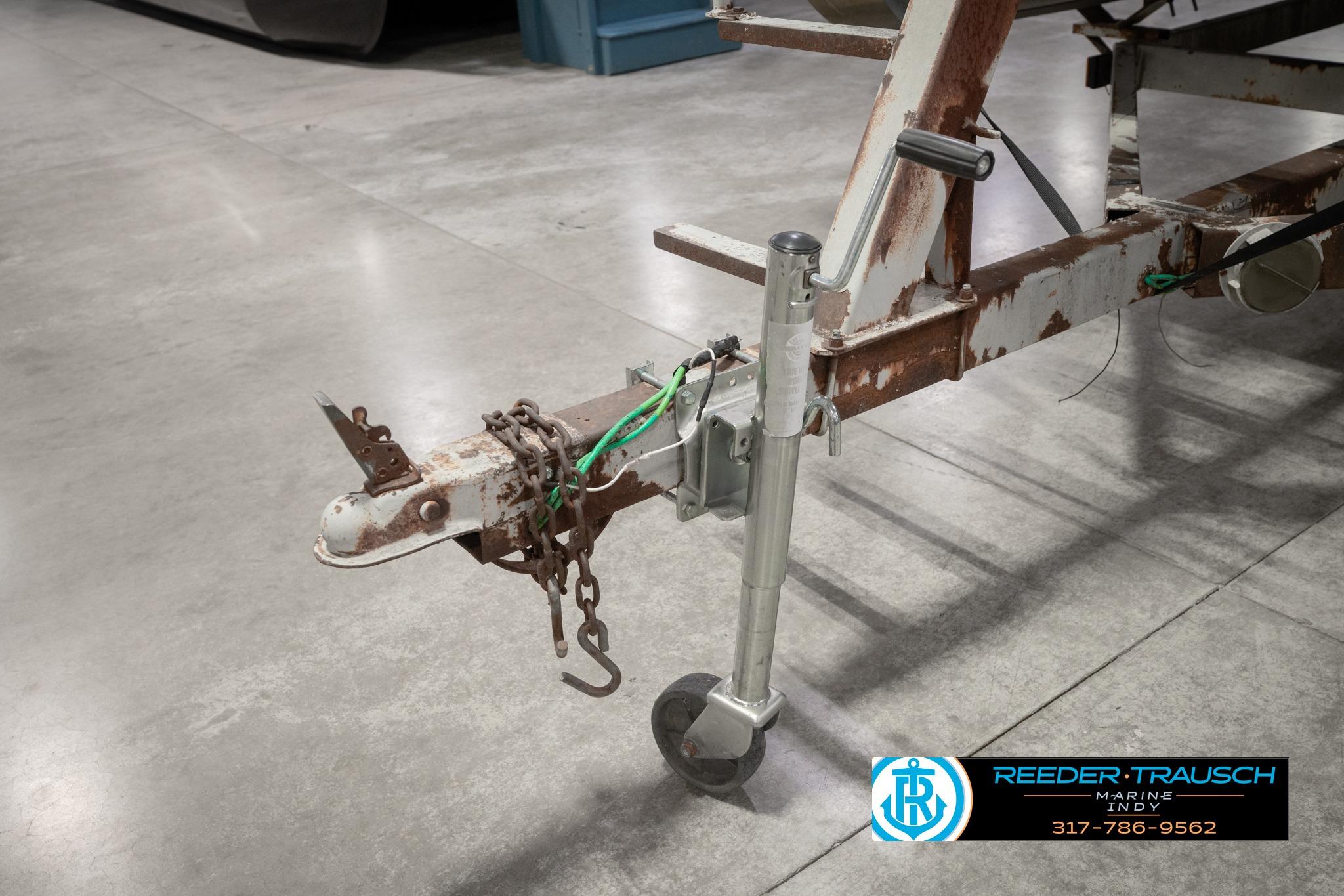 Rusty trailer hitch of a 1992 Godfrey Sweetwater boat, indoors on concrete floor.