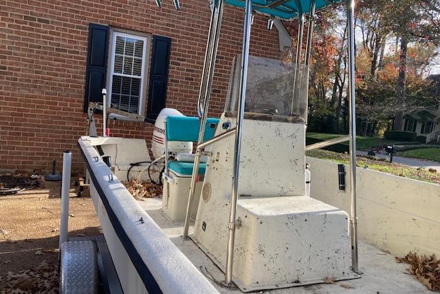 1997 Carolina Skiff 198 DLV boat with center console and outboard motor, parked near brick house.