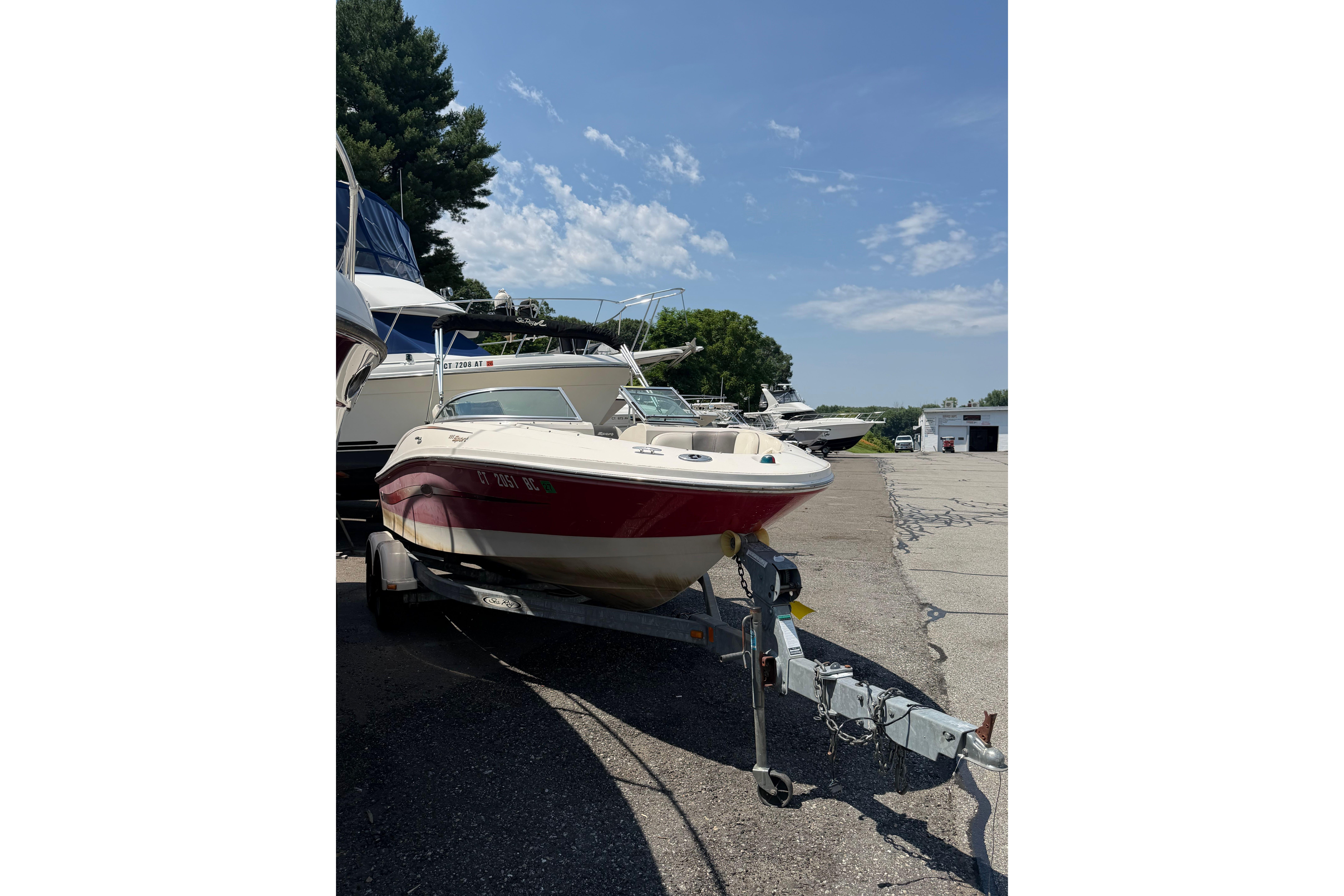 2006 Sea Ray 195 Sport boat on trailer, parked outdoors under clear sky.