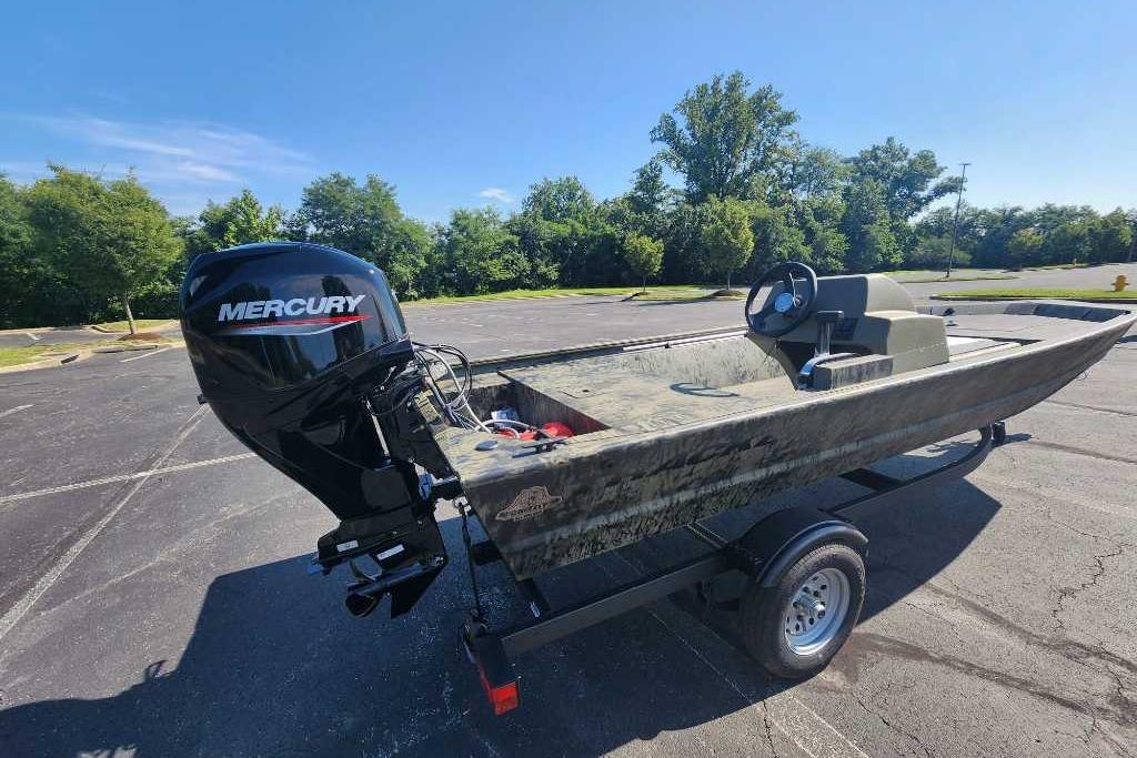 2026 Tracker Grizzly 1648 SC boat with Mercury outboard motor in a parking lot.