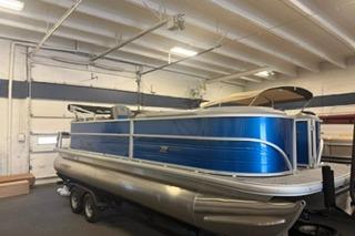 2026 Sun Tracker Party Barge 22 DLX pontoon boat in indoor storage.