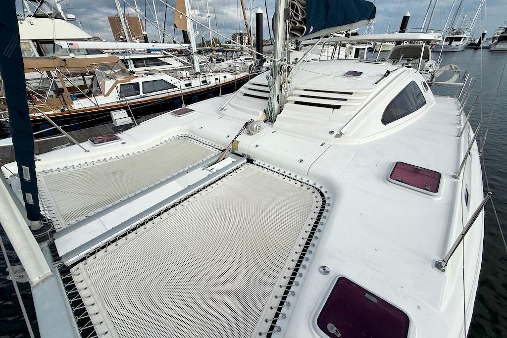 2006 Island Spirit 401 catamaran docked at marina, showcasing spacious deck and netting.