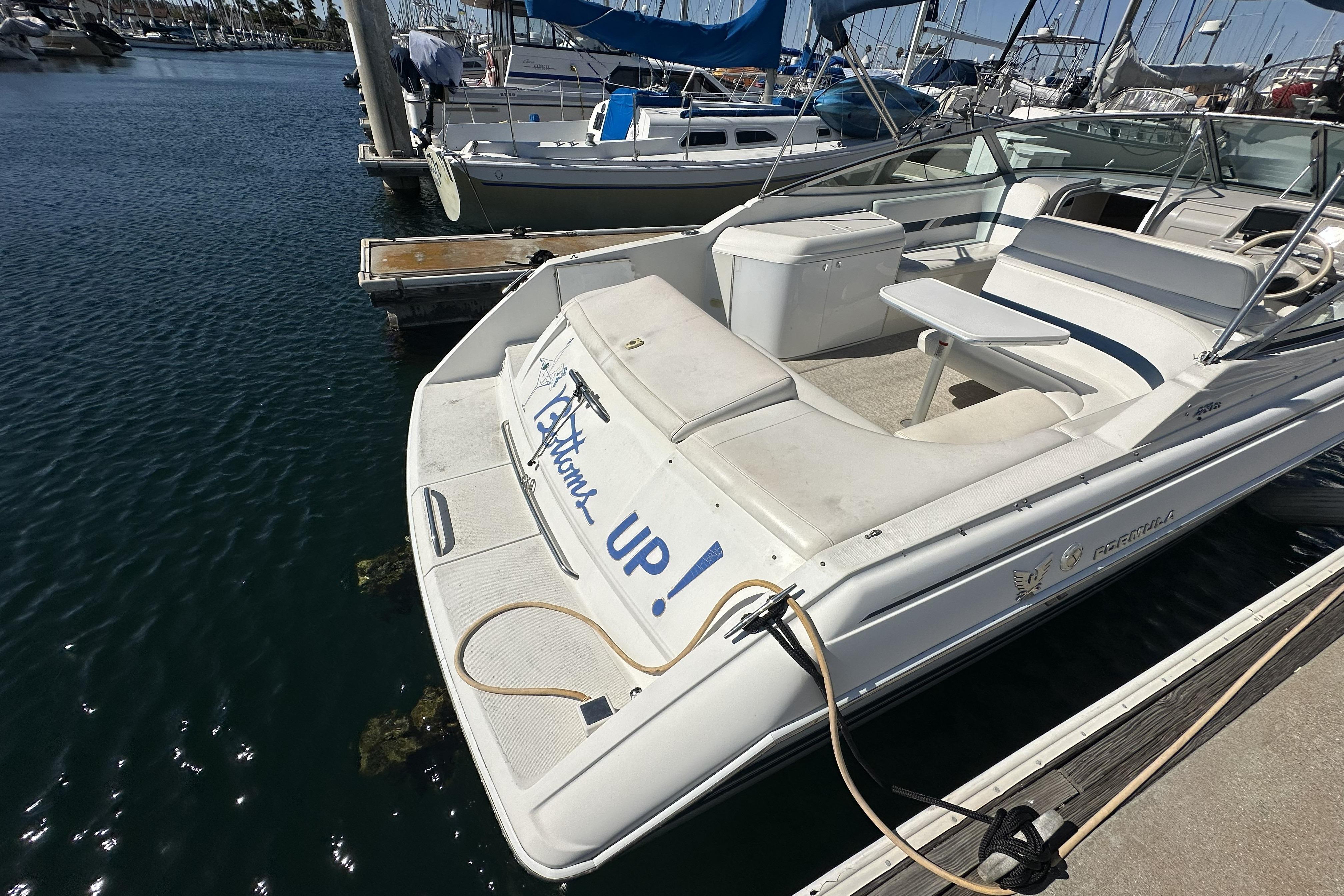 2000 Formula 280 Sun Sport boat docked in marina, featuring spacious seating and clean design.