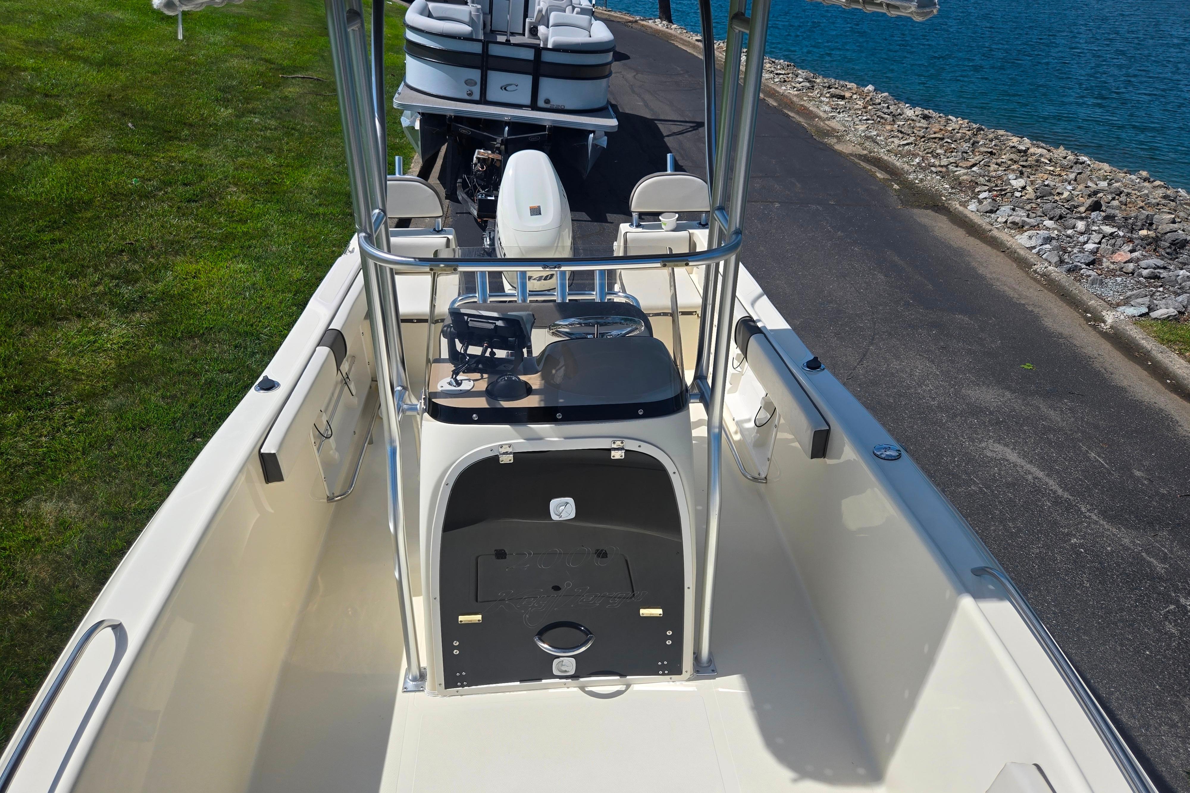2016 Key Largo 2000CC boat with center console, docked near a rocky shoreline.