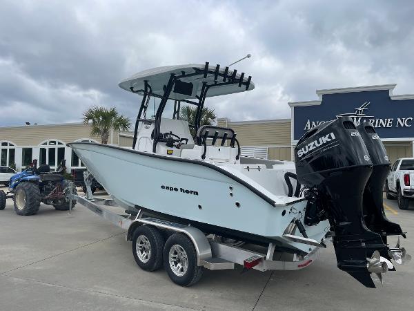 2026 Cape Horn 24XS boat on trailer with Suzuki outboard motor, parked at dealership.
