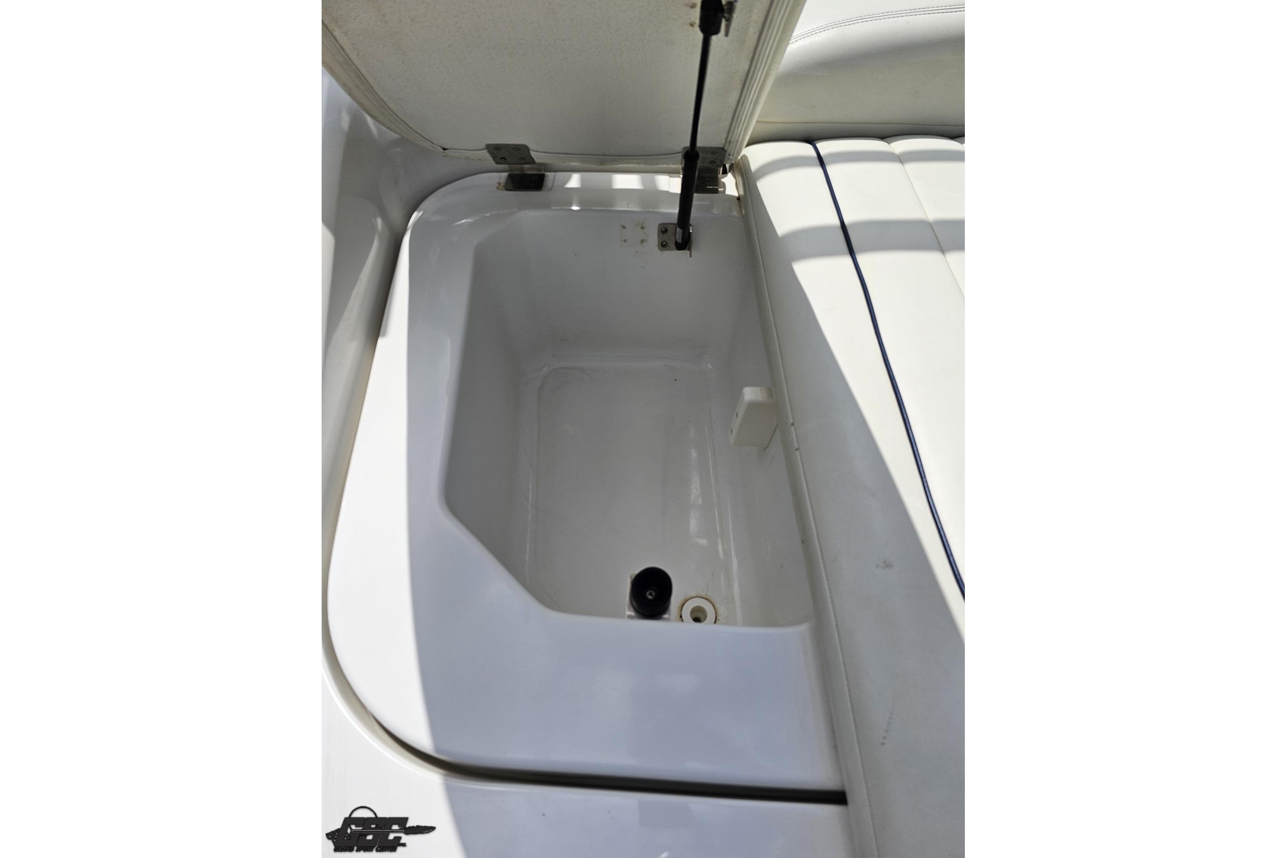 Open storage compartment in 2010 Cobalt 232 WSS boat, featuring white interior.
