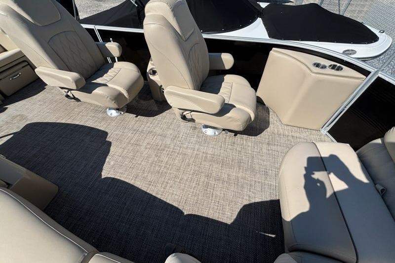2014 Bennington 2575 RCW boat interior with beige seating and carpeted floor.