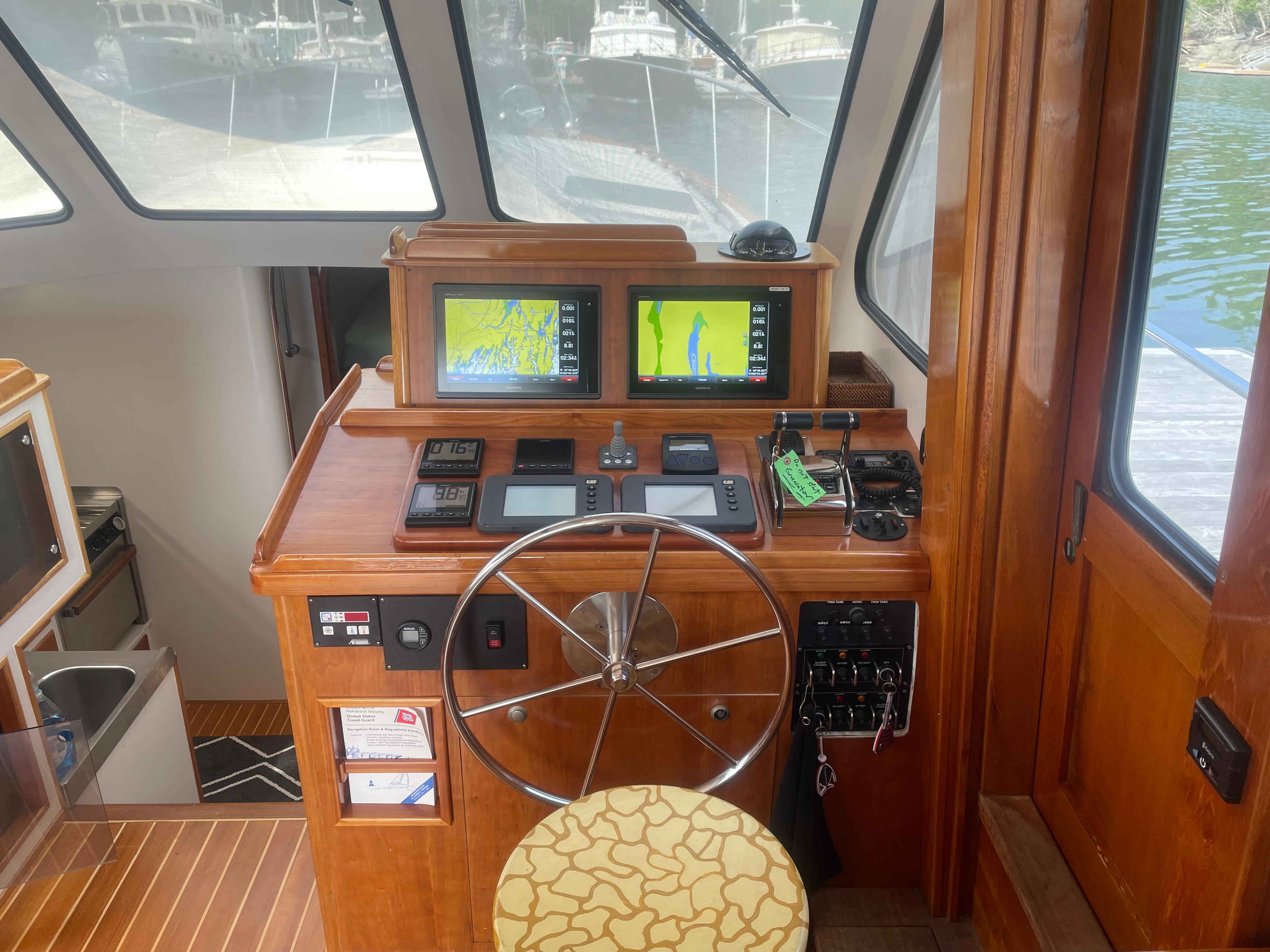 1997 Lyman-Morse Custom Flybridge helm with navigation screens and wooden interior.