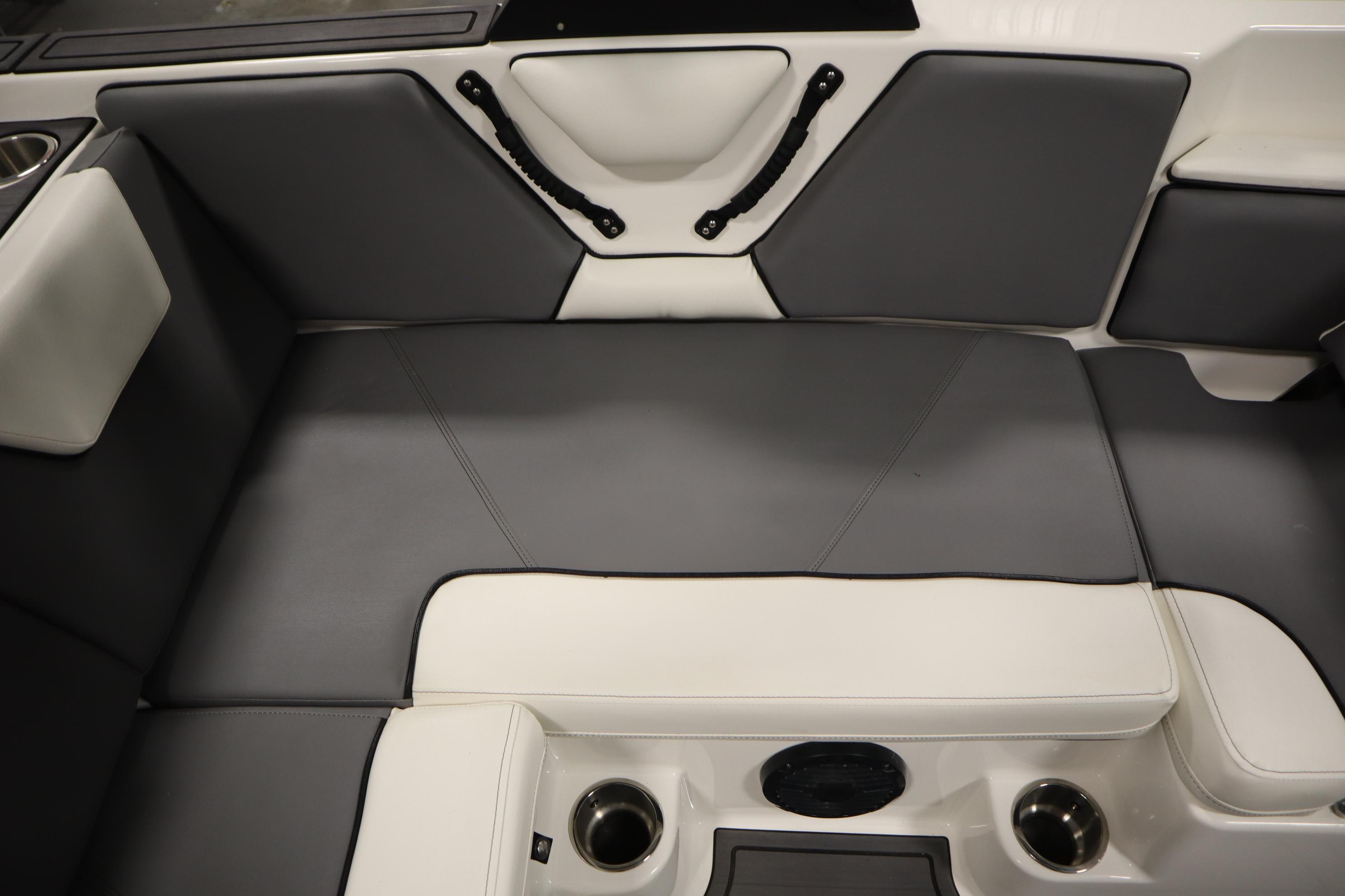 2023 Heyday WT Surf boat interior with gray and white seating and cup holders.