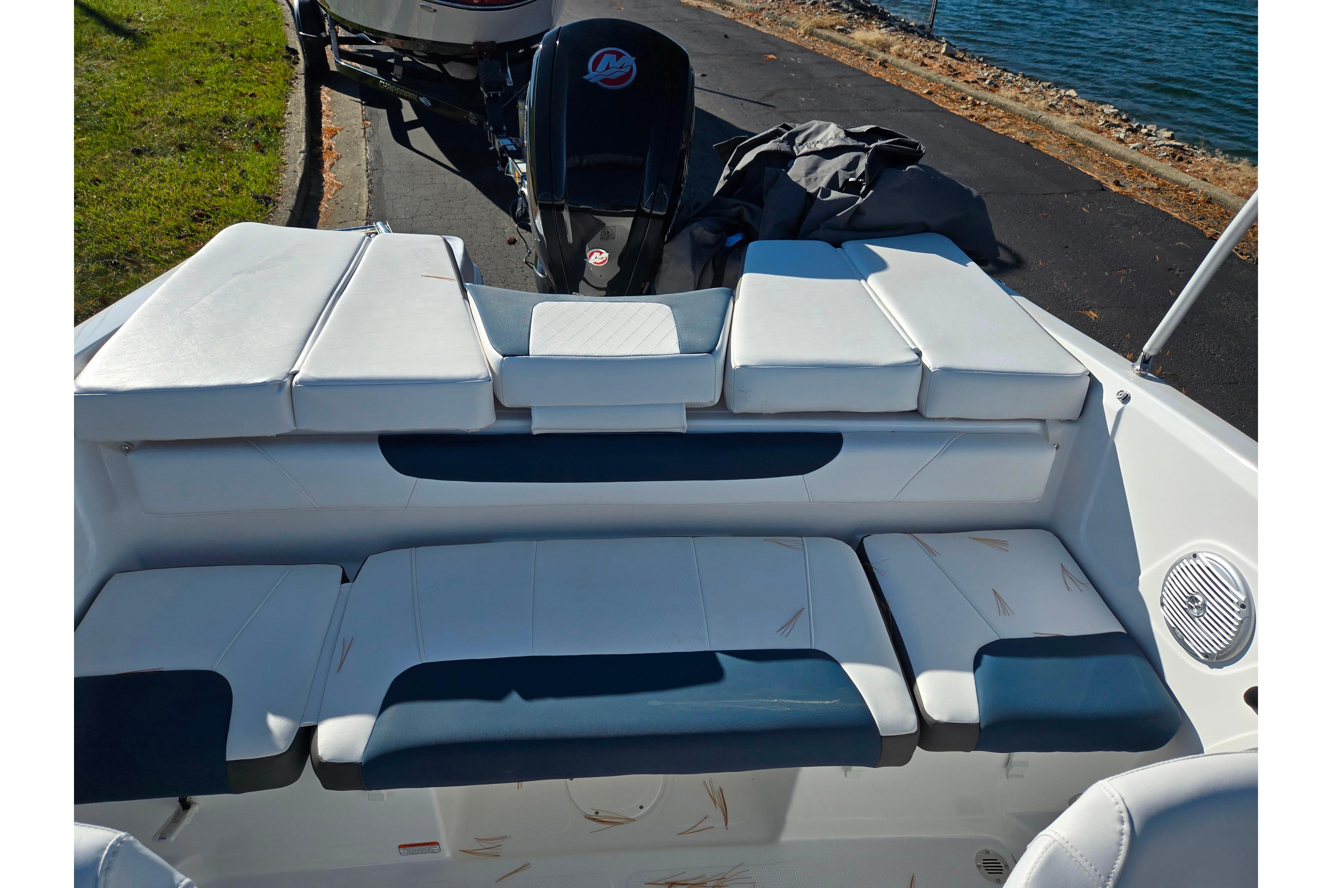 2023 Tahoe 185 S boat interior with cushioned seating and outboard motor by the water.