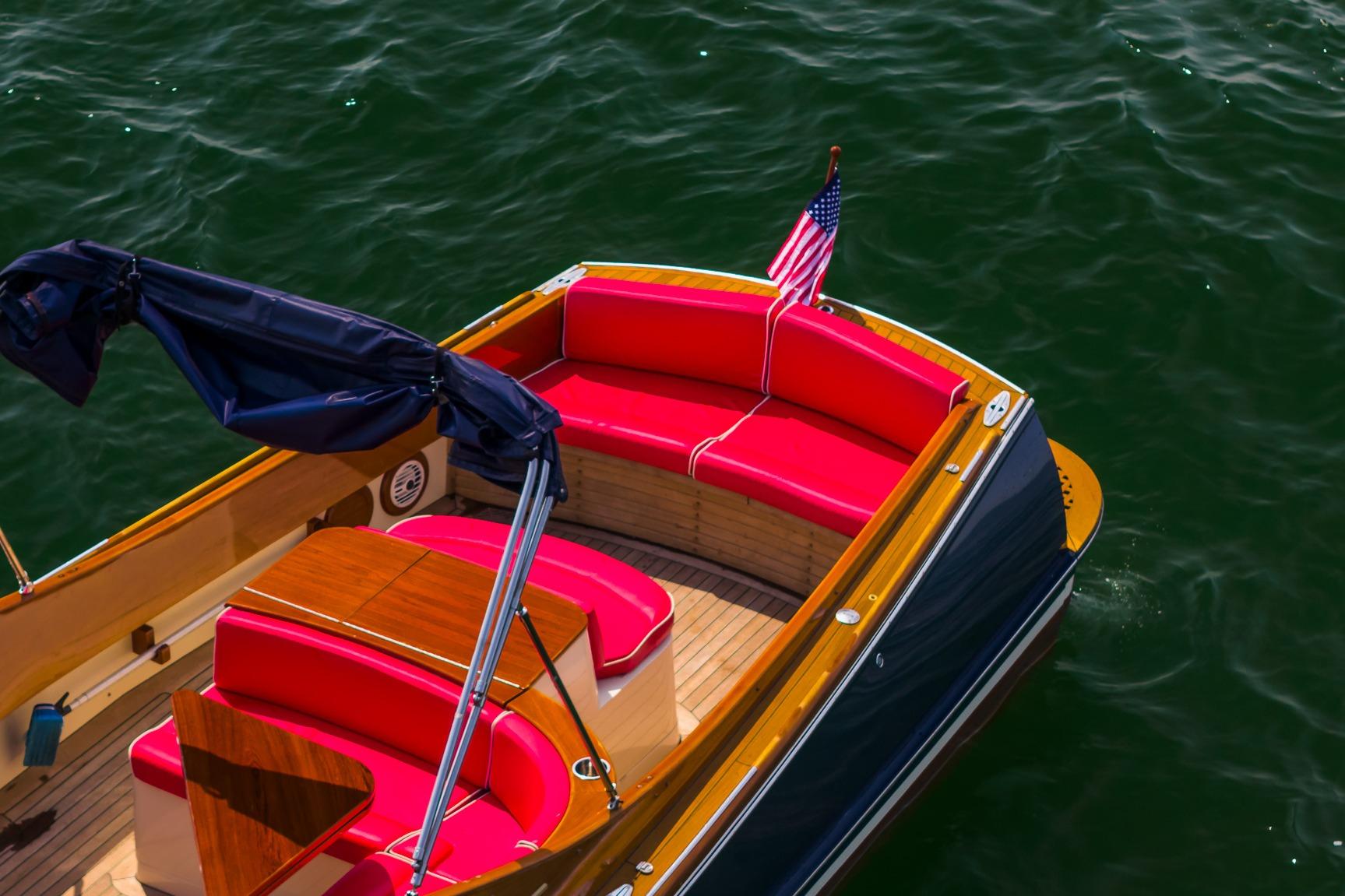 2005 Hinckley Talaria 29R boat with vibrant red seating and American flag on water.