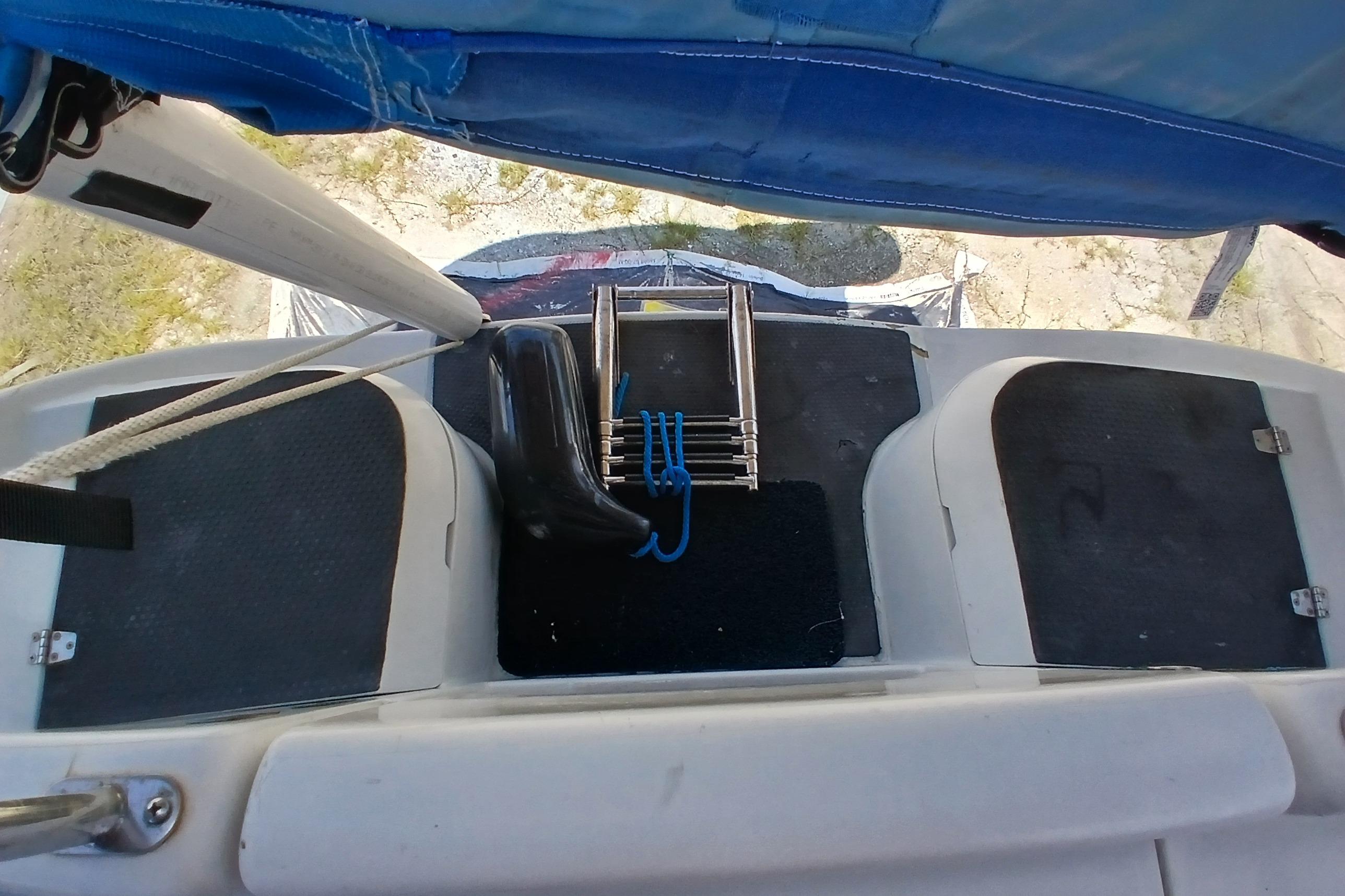Sailboat cockpit view of a 1995 Catalina 42 MkII with ladder and blue rope.