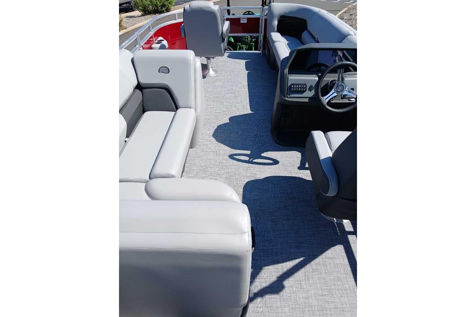 2026 Sun Tracker SportFish 20 DLX pontoon boat interior with gray seating and steering console.