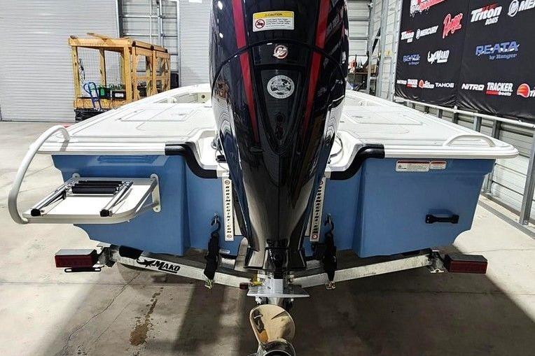 2026 Mako 18 Pro Skiff boat in showroom, rear view with outboard motor.